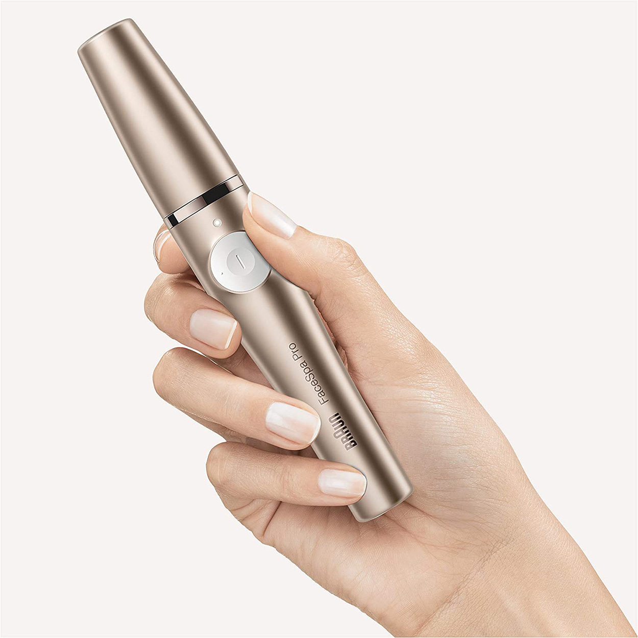 Dłoń kobiety trzymająca złote urządzenie Braun FaceSpa Pro.