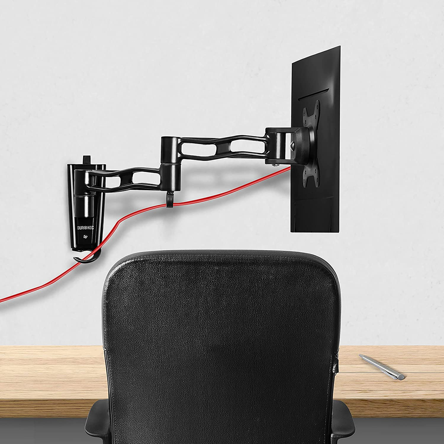 Schwarzer Monitorarm an einer weißen Wand montiert. Ein rotes Kabel verläuft an der Wand entlang.