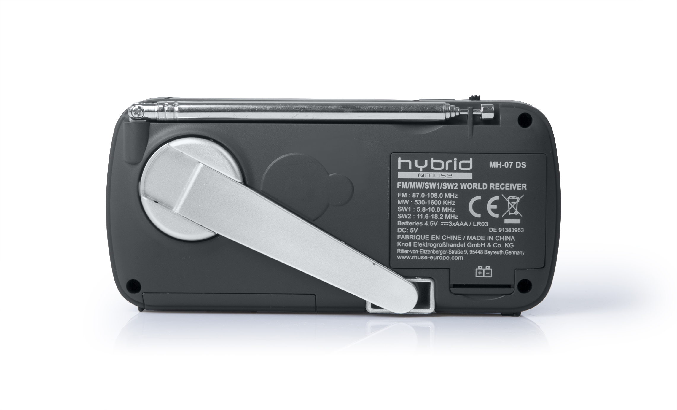 The back of a dark gray portable radio, with a handle and antenna.