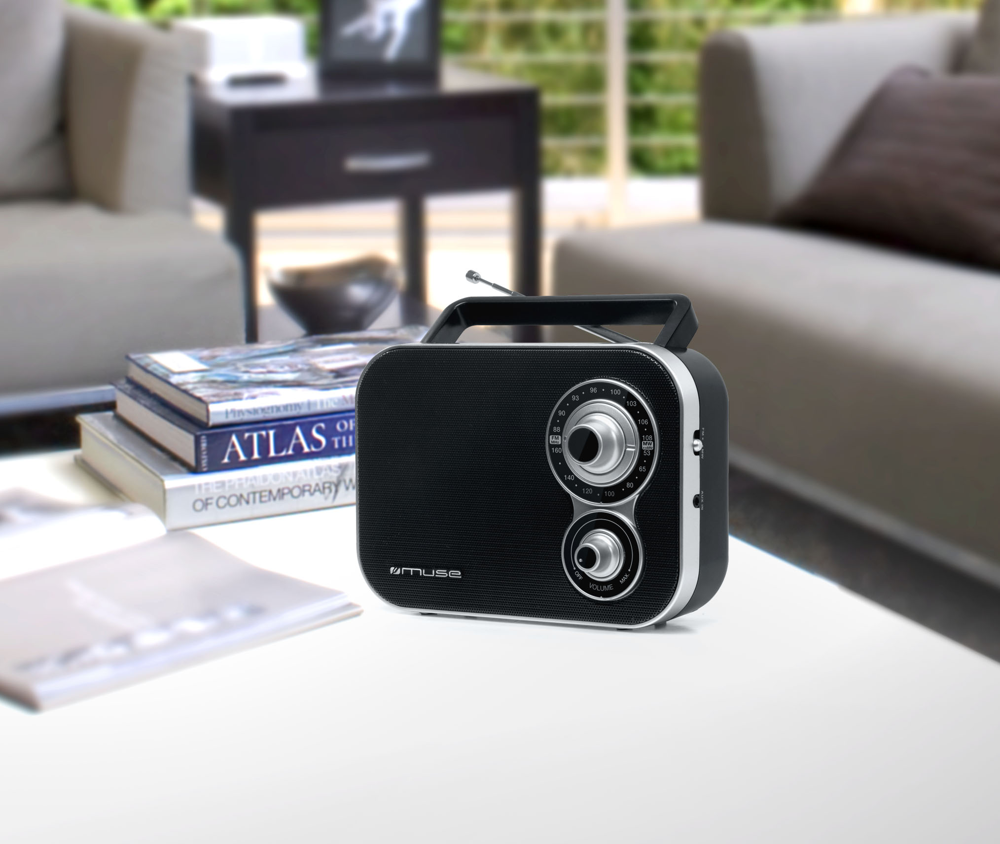 Czarny radioodbiornik z uchwytem na stole na tle rozmytego tła.