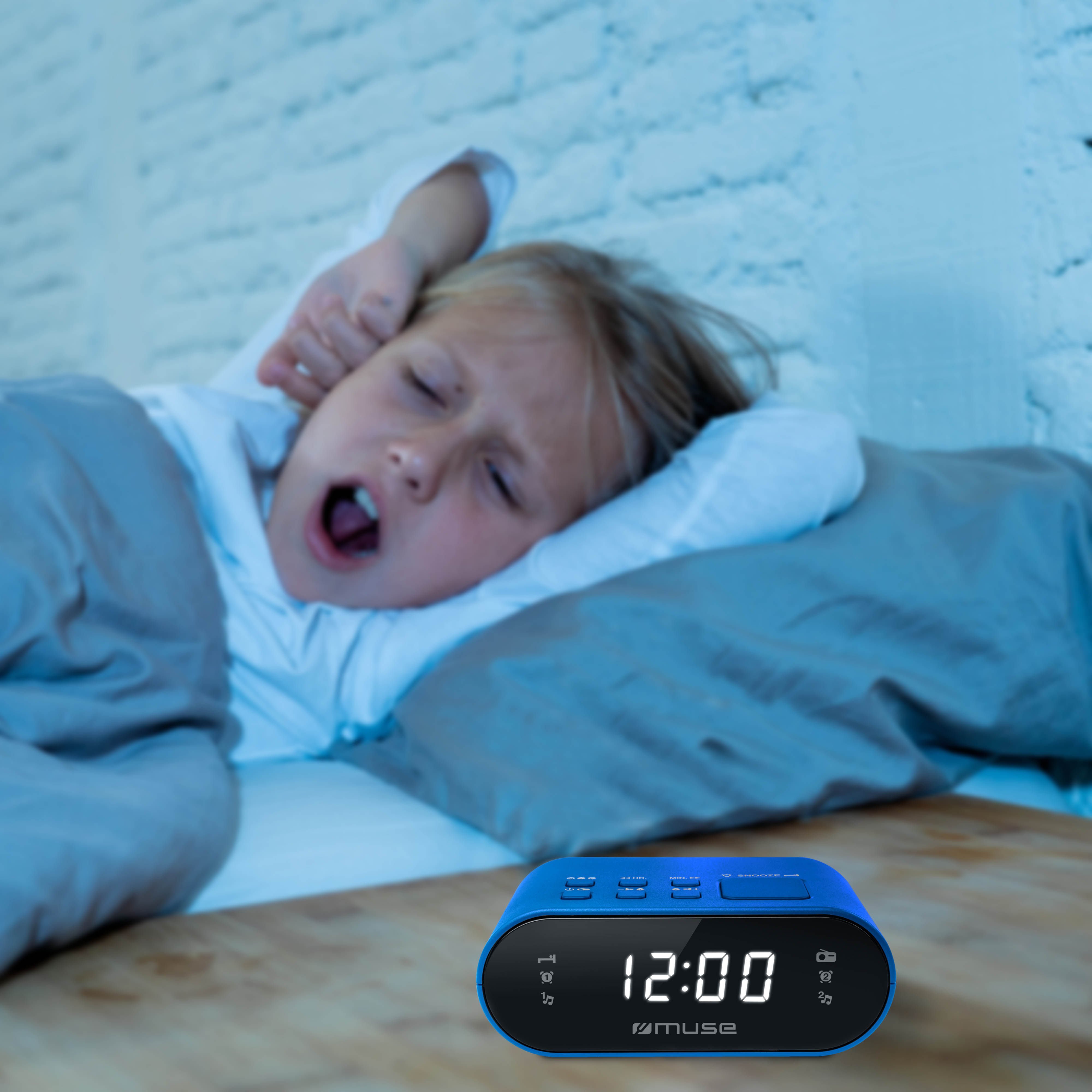 Un despertador azul con la hora 12:00. Una niña se tapa los oídos.