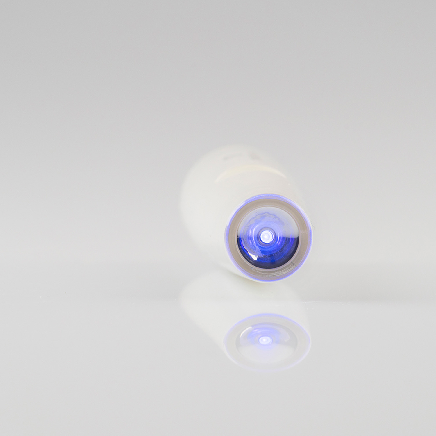 A white object with a blue light emitting from the bottom. It's reflected on the surface.