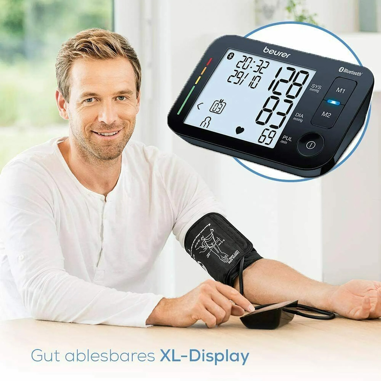 Hombre mide la presión arterial con un dispositivo en el brazo. El dispositivo muestra lecturas. Texto: XL-Display.