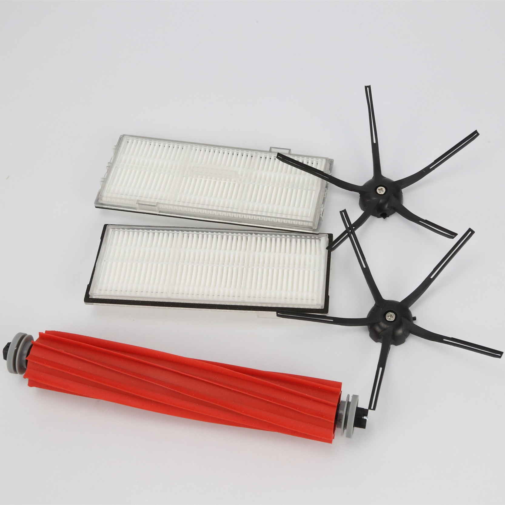 Części robota sprzątającego: dwa filtry, czerwona szczotka rolkowa i dwie czarne szczotki boczne na białym tle.