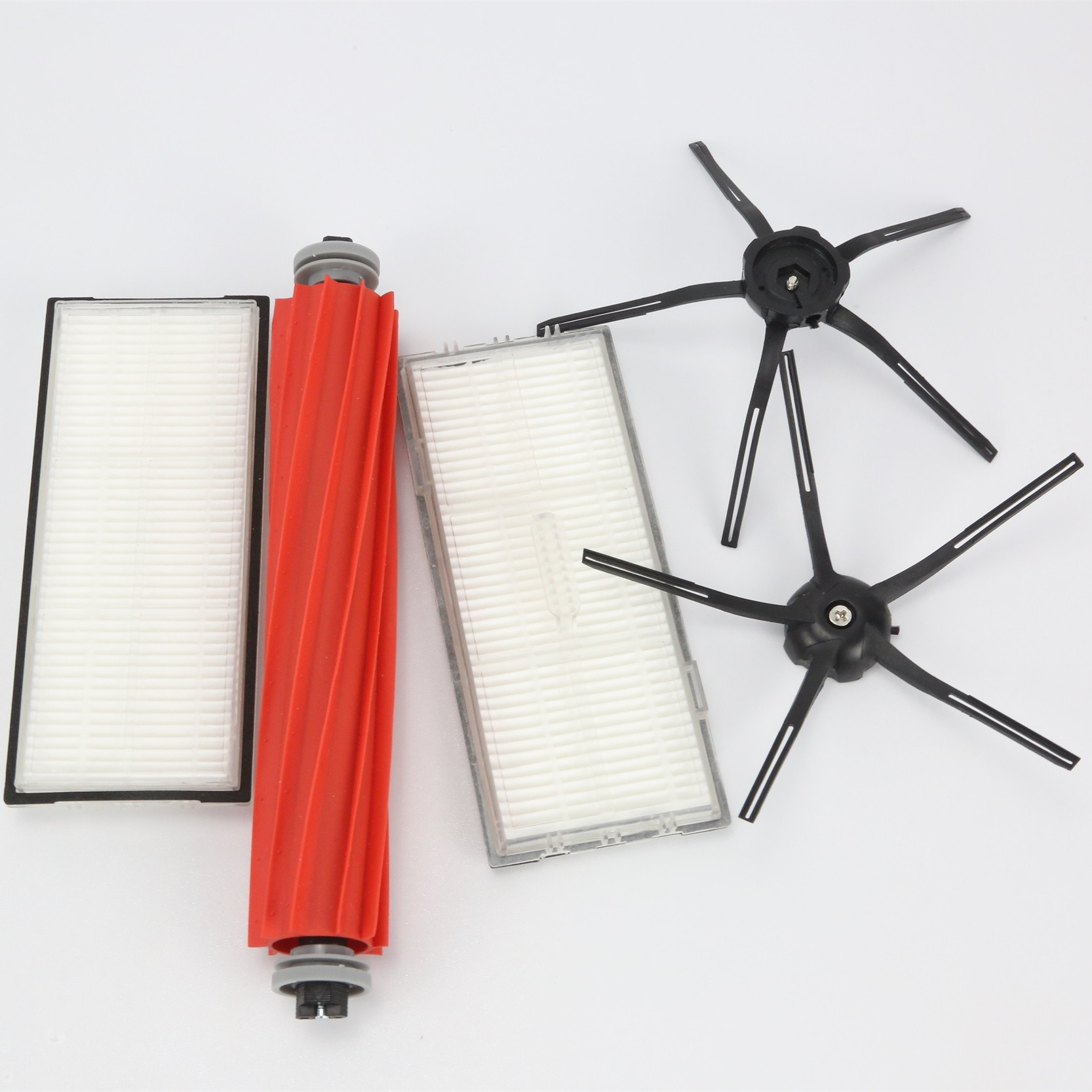 Części robota sprzątającego: wałek szczotki, filtry i szczotki boczne. Wszystkie są oddzielne i na białej powierzchni.