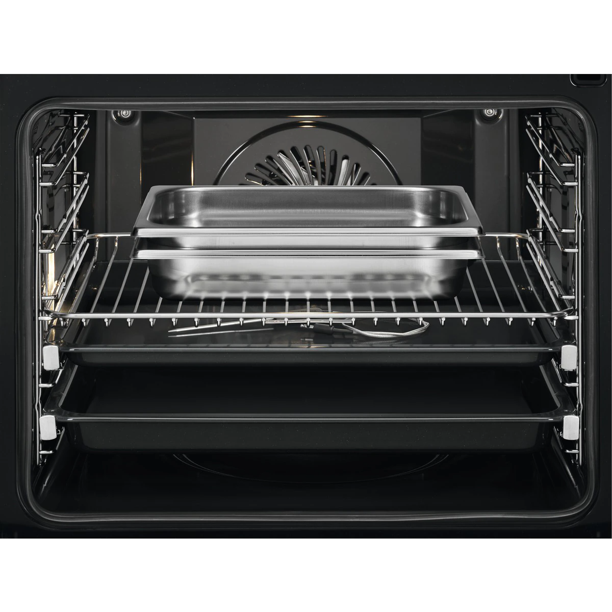 Wnętrze piekarnika z tacami i metalowym rusztem, widok od wewnątrz, w kuchni.