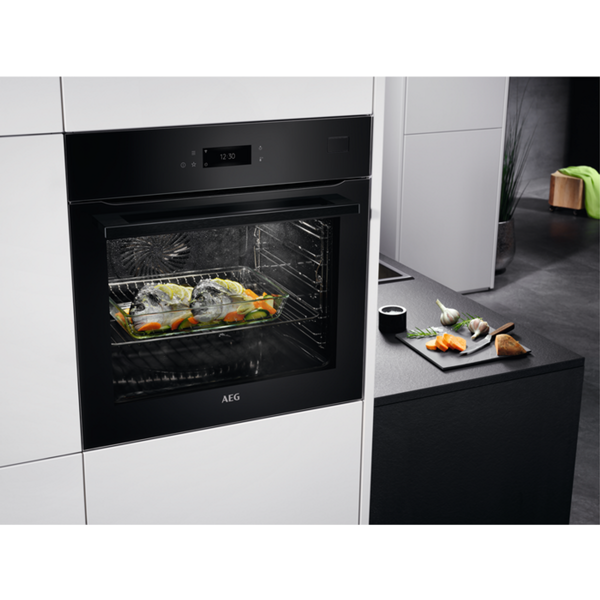 Horno AEG con comida dentro. Puerta abierta. Cocina blanca y negra.