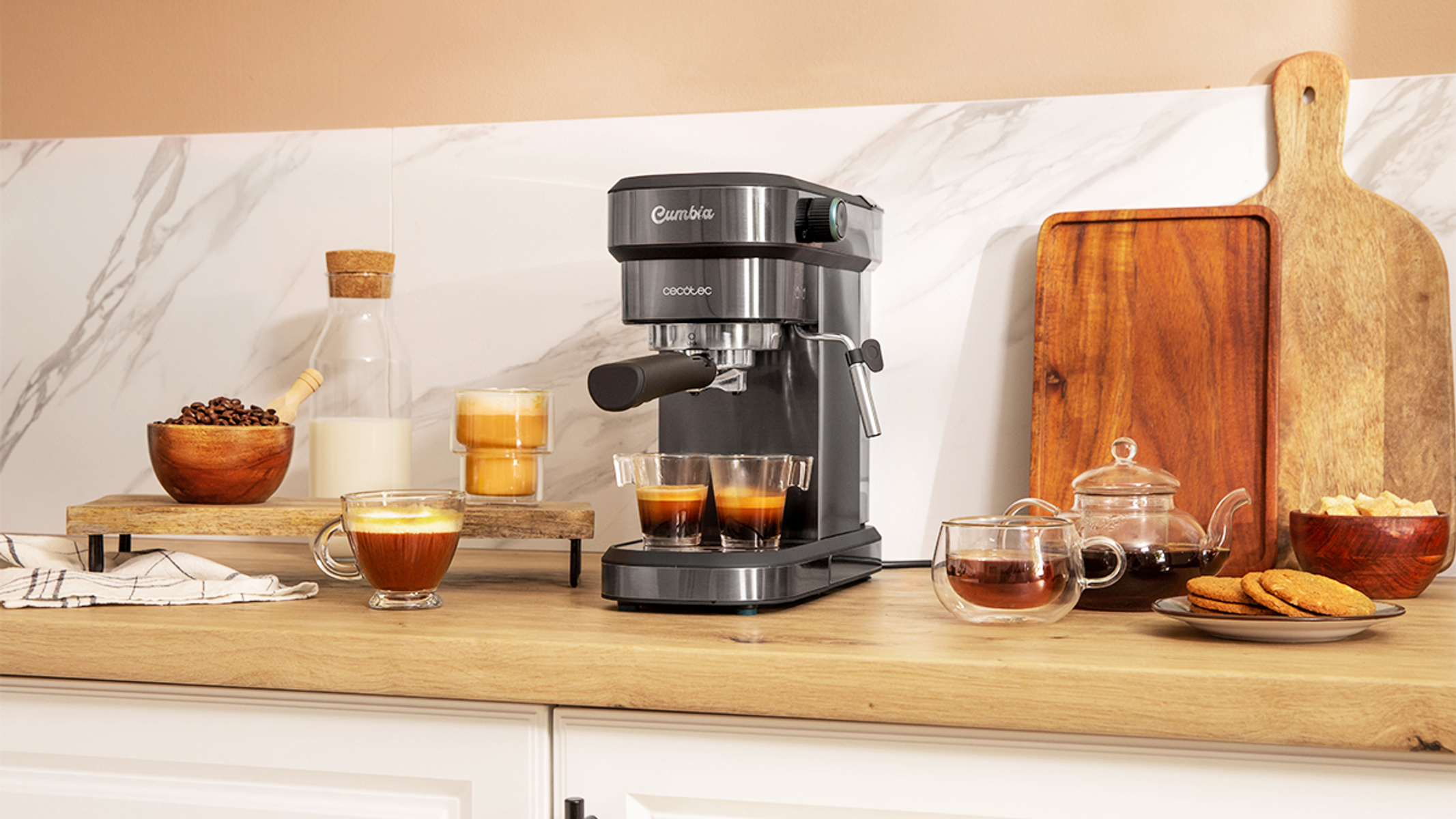 Ekspres do kawy z dwoma espresso. Zawiera ziarna kawy, mleko i wypieki na drewnianym blacie.