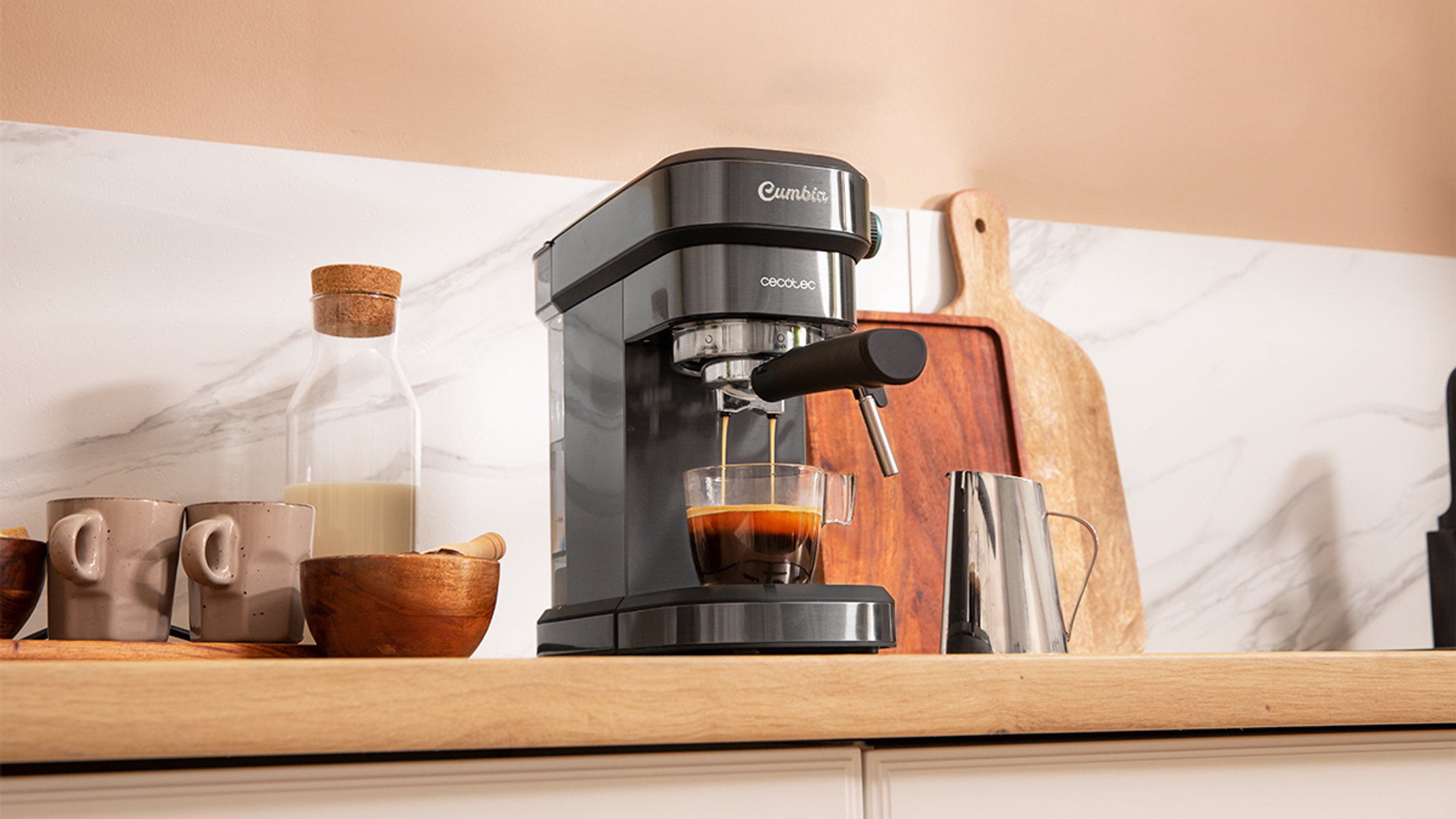 Ekspres do espresso z filiżanką kawy. Drewniana deska i dzbanek do mleka na blacie.