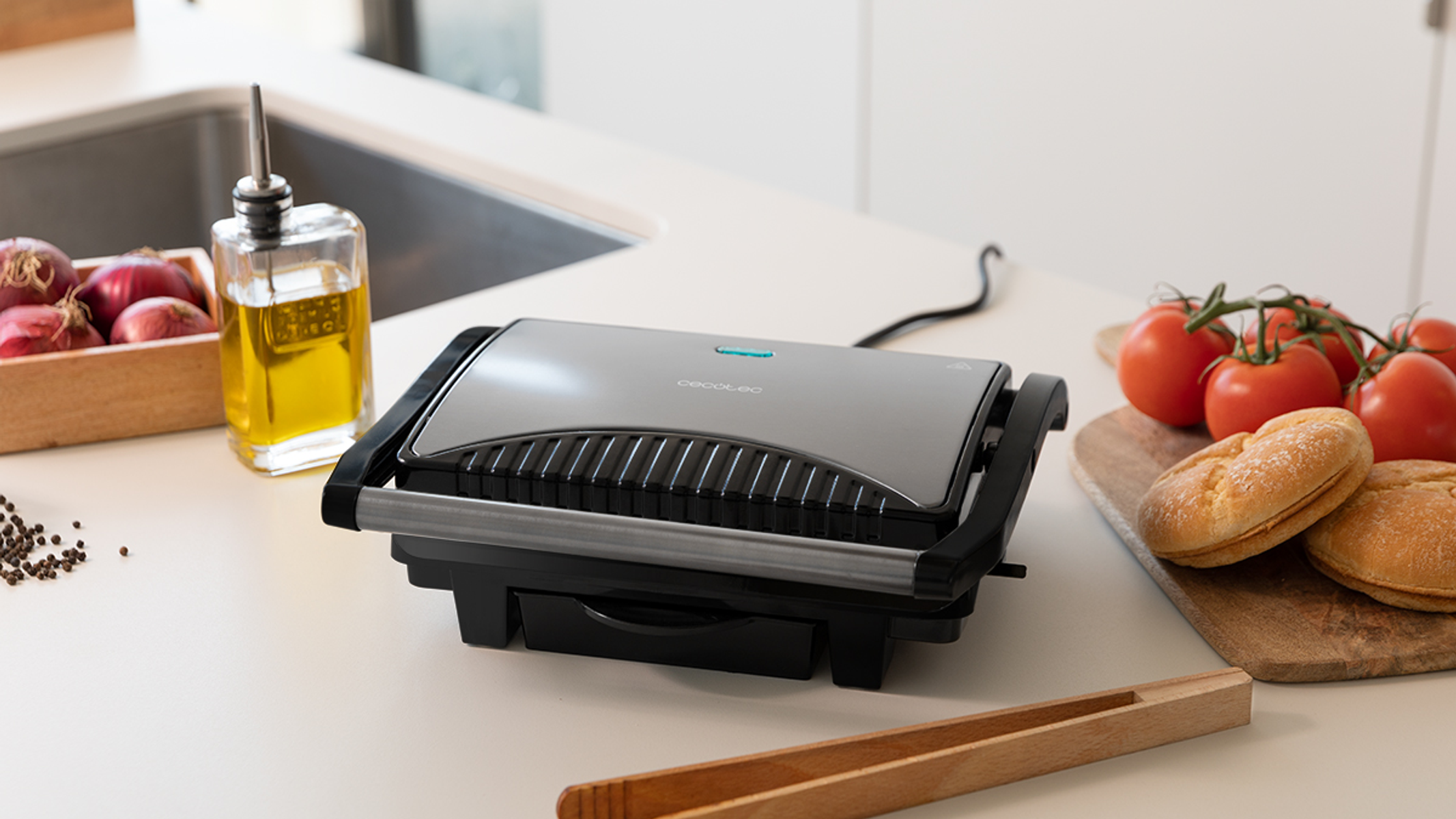 Toster do kanapek ze składnikami na białym blacie.