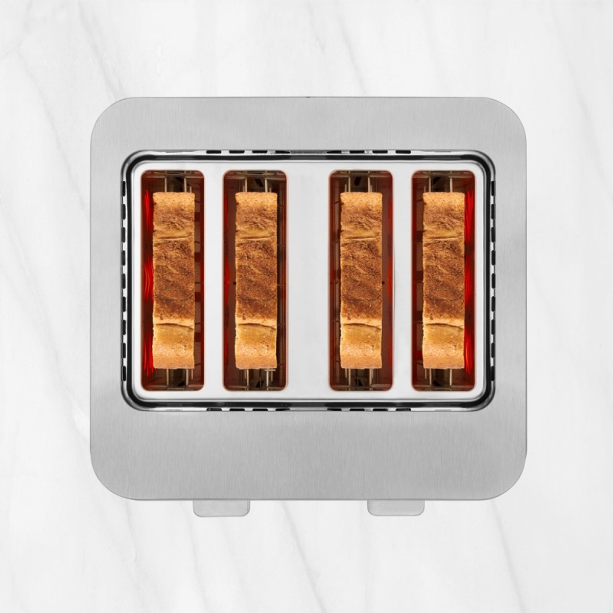 Ein Edelstahl-Toaster für vier Scheiben mit Toast, auf einer Marmoroberfläche.