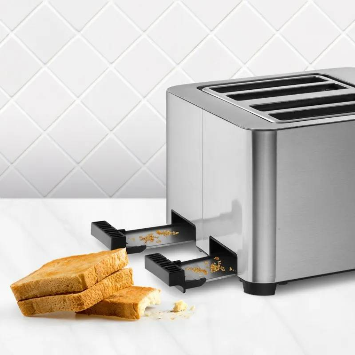 Silberner Toaster mit Toastbrotscheiben und Krümeln.