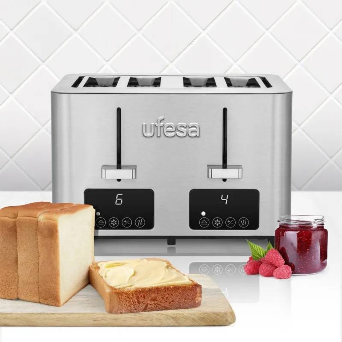 Ein silberner Ufesa-Toaster mit zwei Schlitzen, Brot, Butterbrot und ein Glas Marmelade auf dem Tisch.