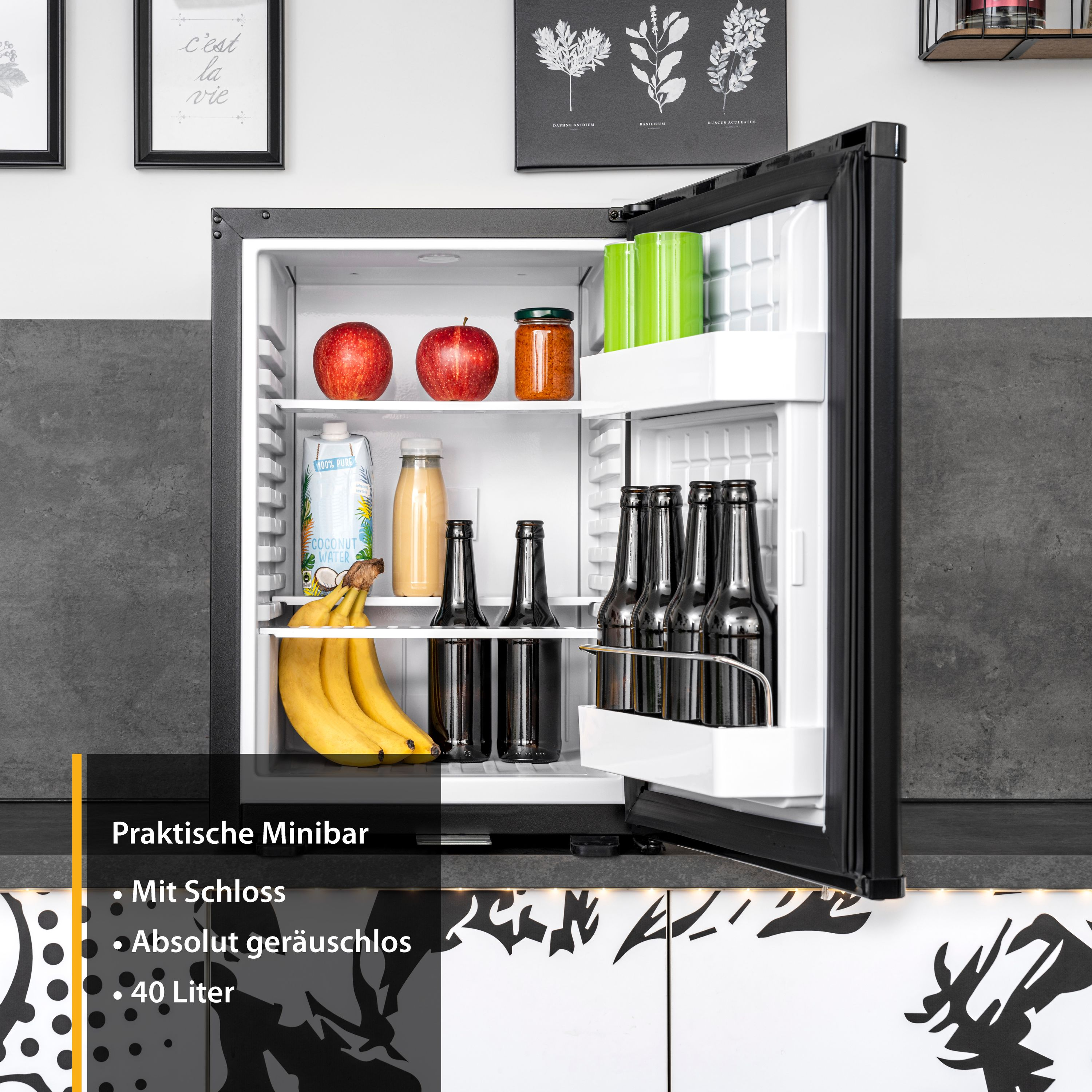 Ein Mini-Kühlschrank mit offener Tür. Innen befinden sich Früchte, Getränke und Glasflaschen.