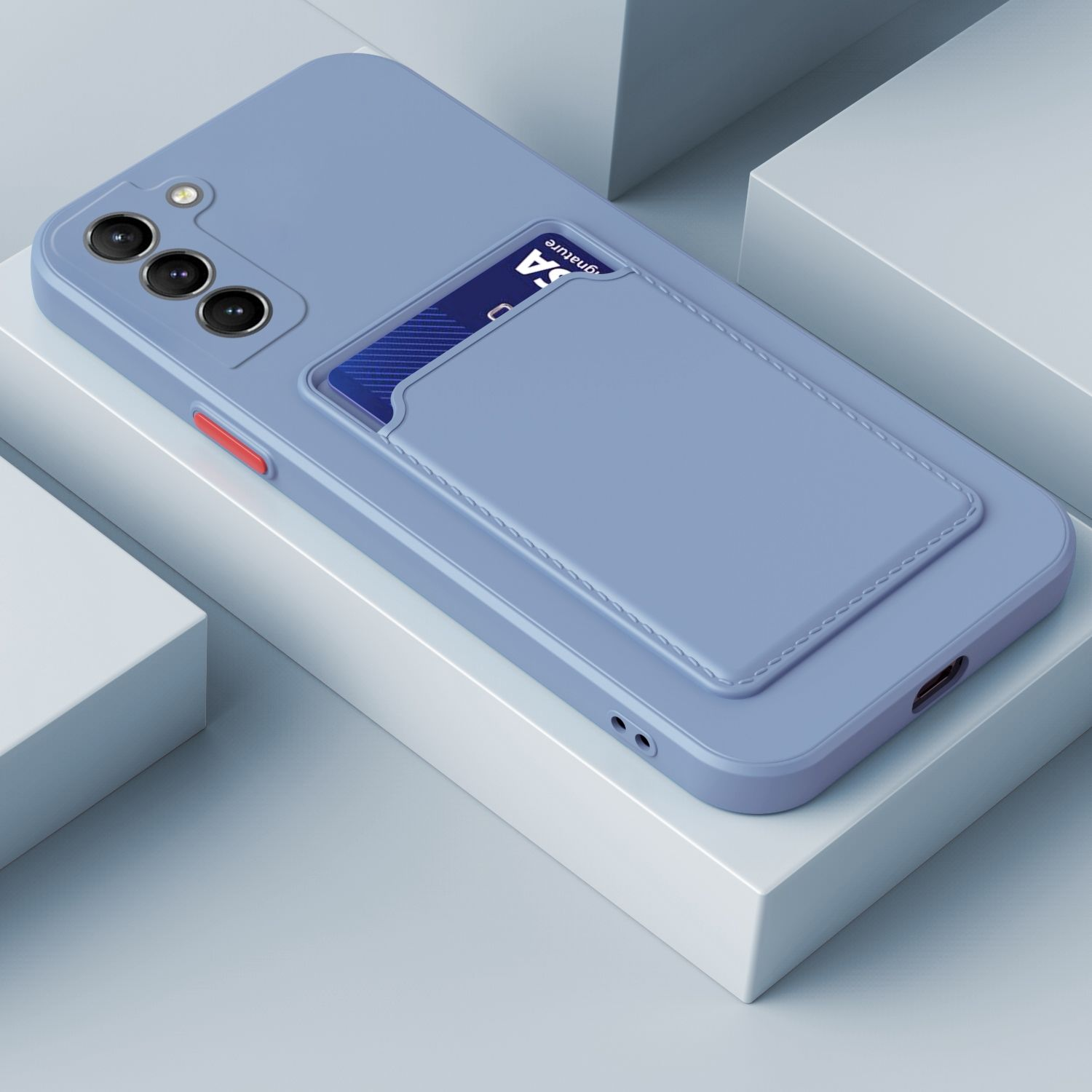 Eine blaue Handyhülle mit Kartenfach, eine blaue Karte und eine Kamera auf weißer Oberfläche.