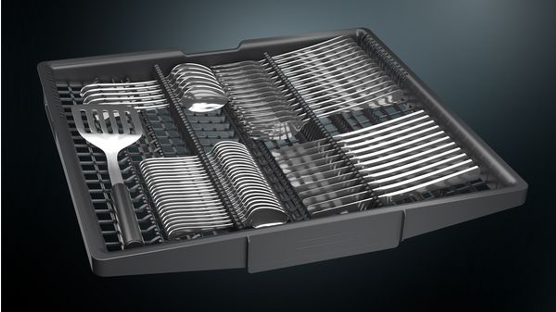 Tacka na sztućce w zmywarce, wypełniona sztućcami i szpatułką.