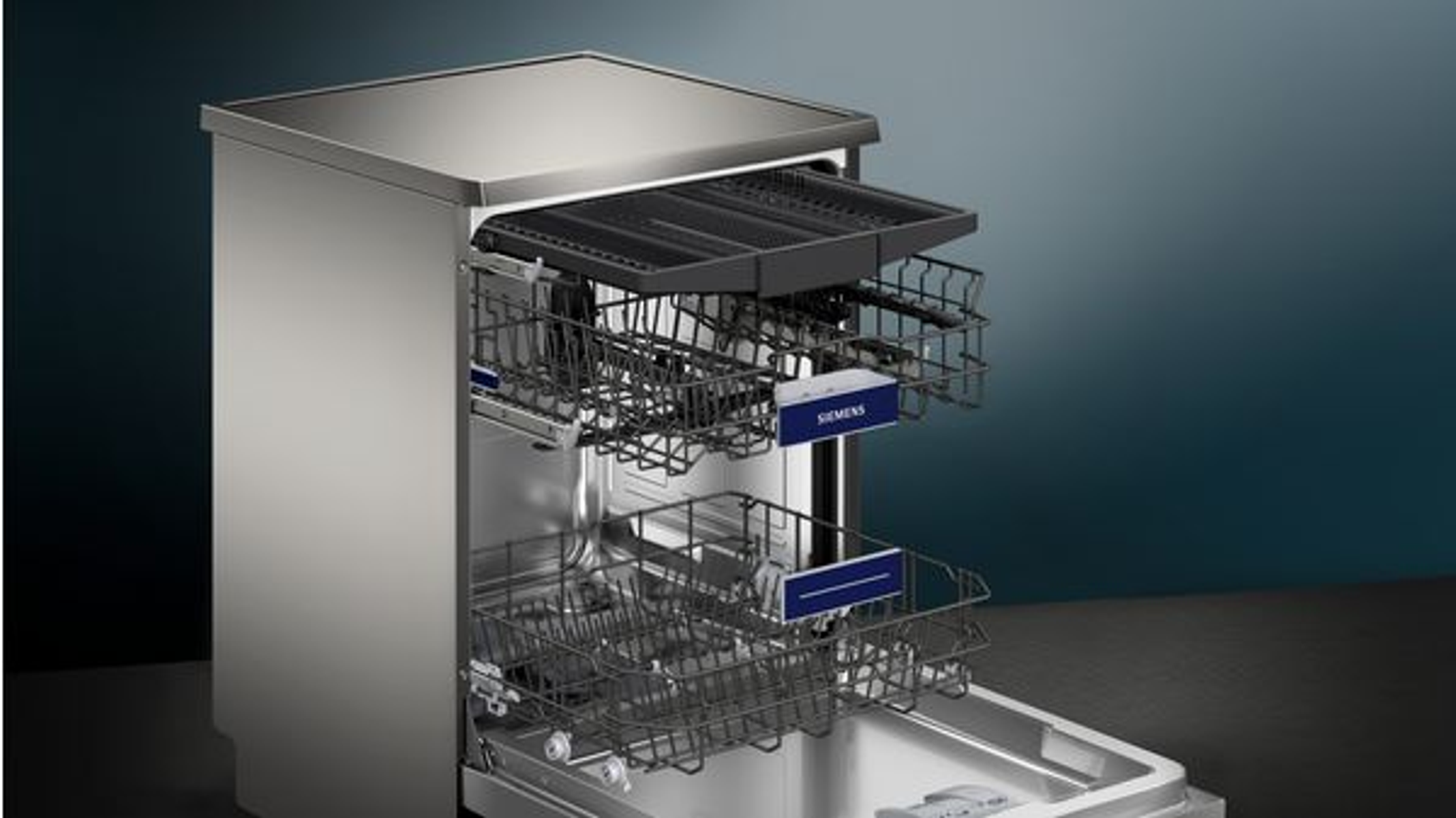 Otwarta zmywarka ze stali nierdzewnej z dwoma stojakami w środku.