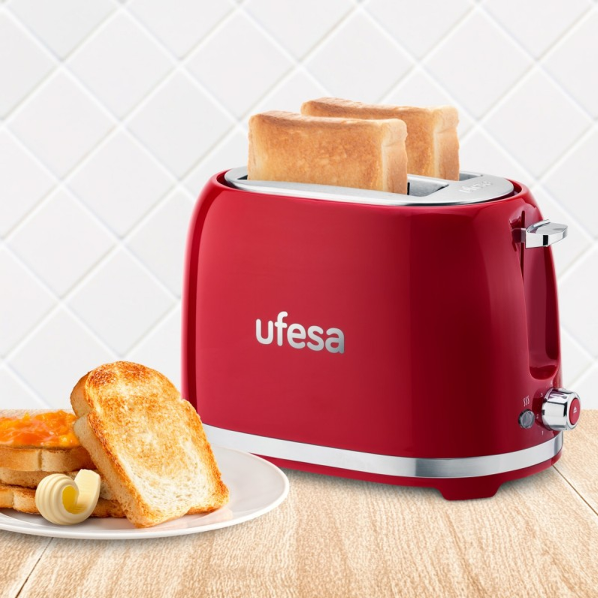 Czerwony toster Ufesa z dwiema kromkami tostów i masłem. Tło: kafelkowa ściana.
