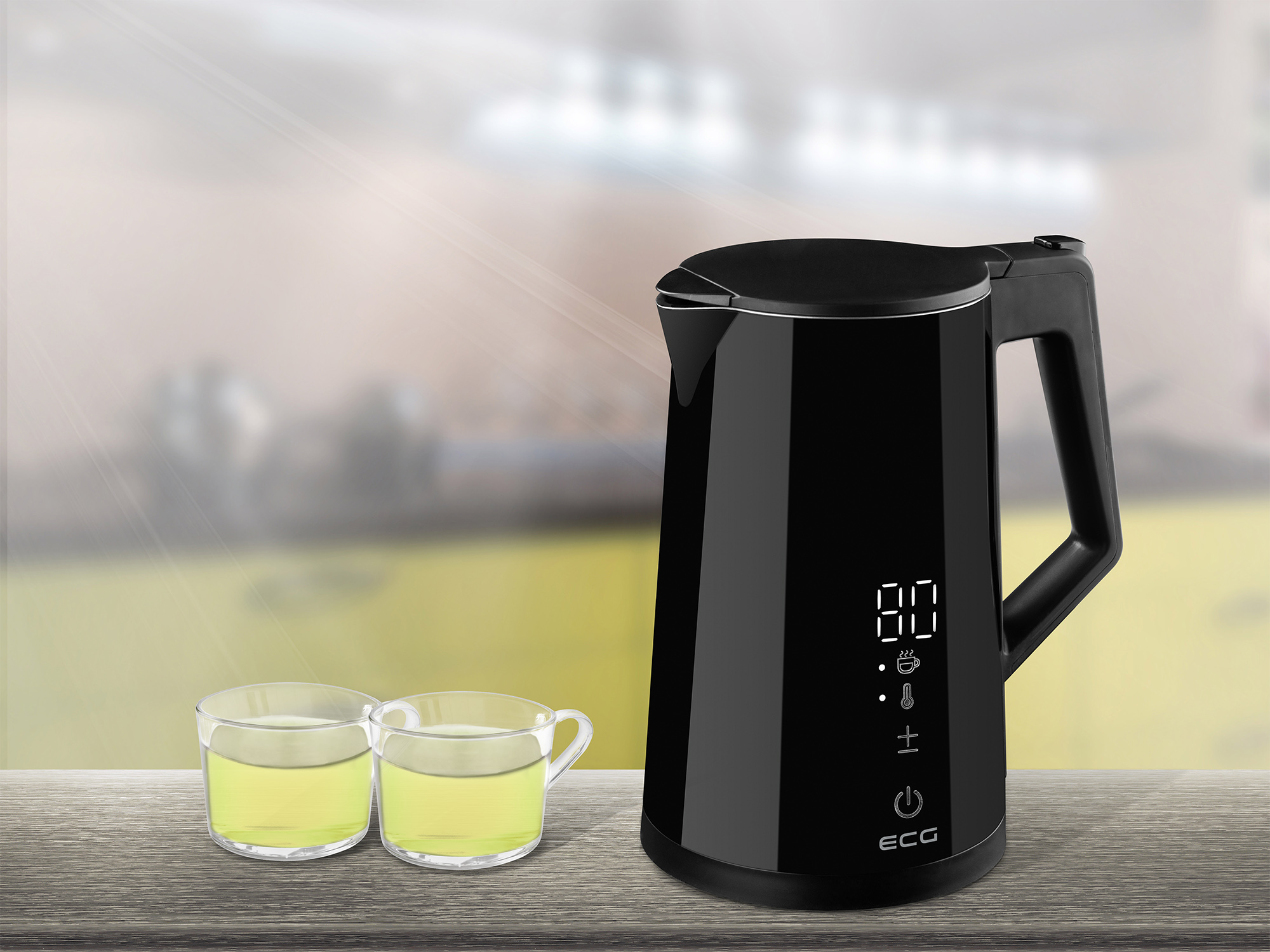 Czarny czajnik elektryczny z cyfrowym wyświetlaczem i dwoma szklankami zielonego płynu.
