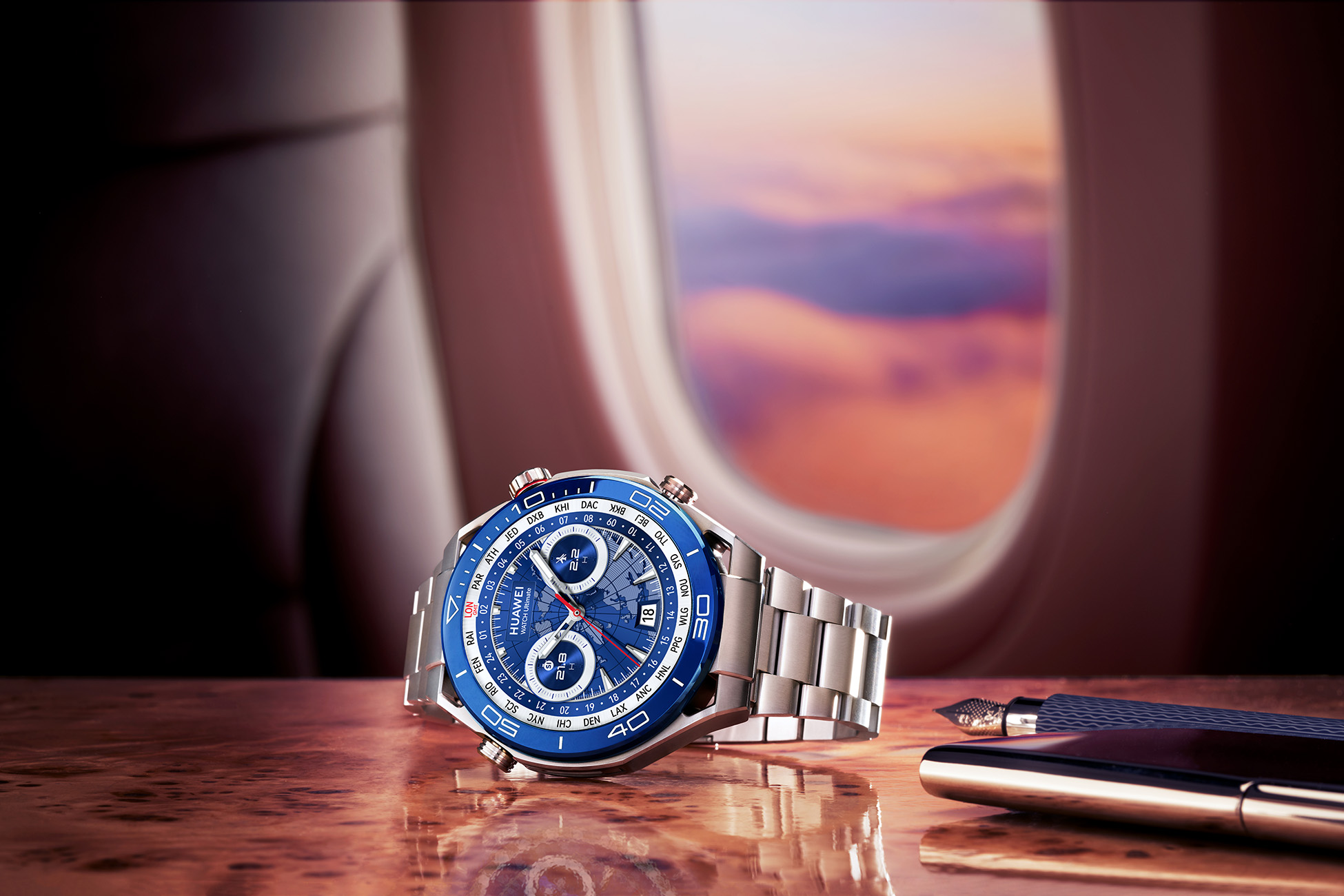 Un orologio con quadrante blu e cinturino argentato su un tavolo di legno. Una penna vicina.
