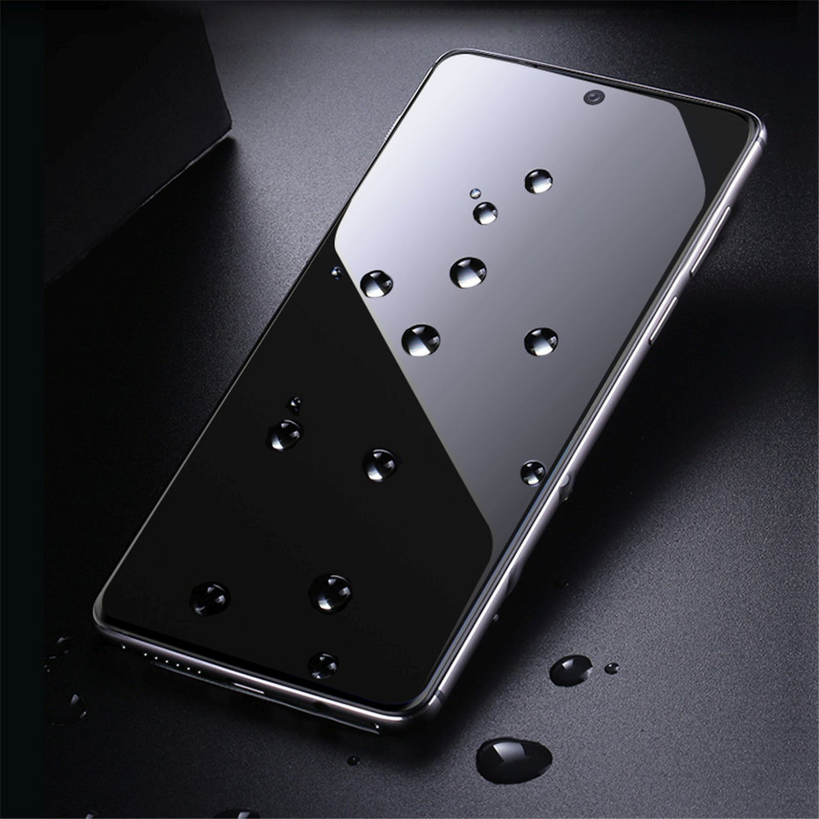 Schwarzes Telefon mit Wassertropfen. Dunkler Hintergrund. Telefon liegt auf Oberfläche.