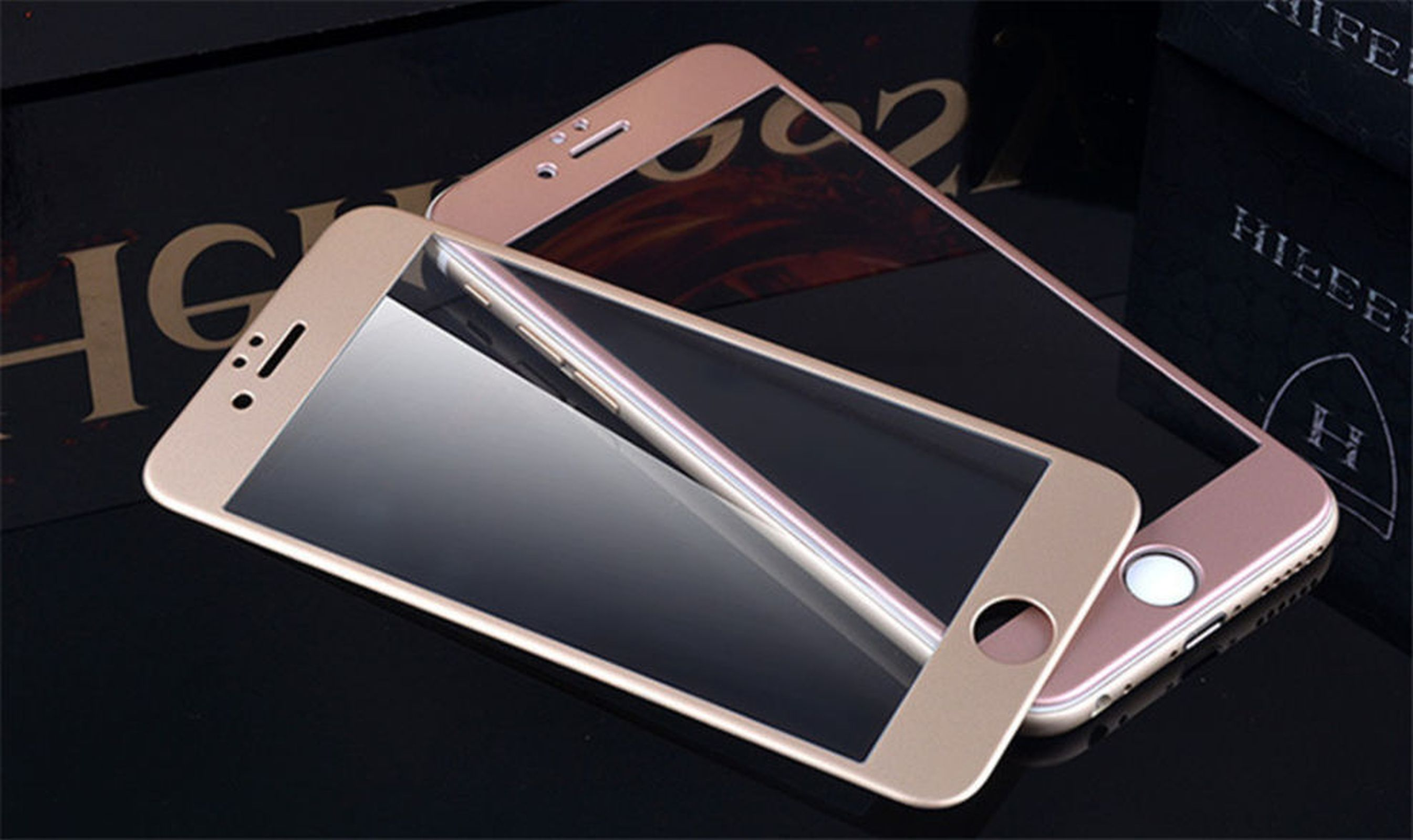 Zwei Telefone mit Displayschutz. Die Schutzvorrichtungen sind goldfarben und glänzend schwarz.