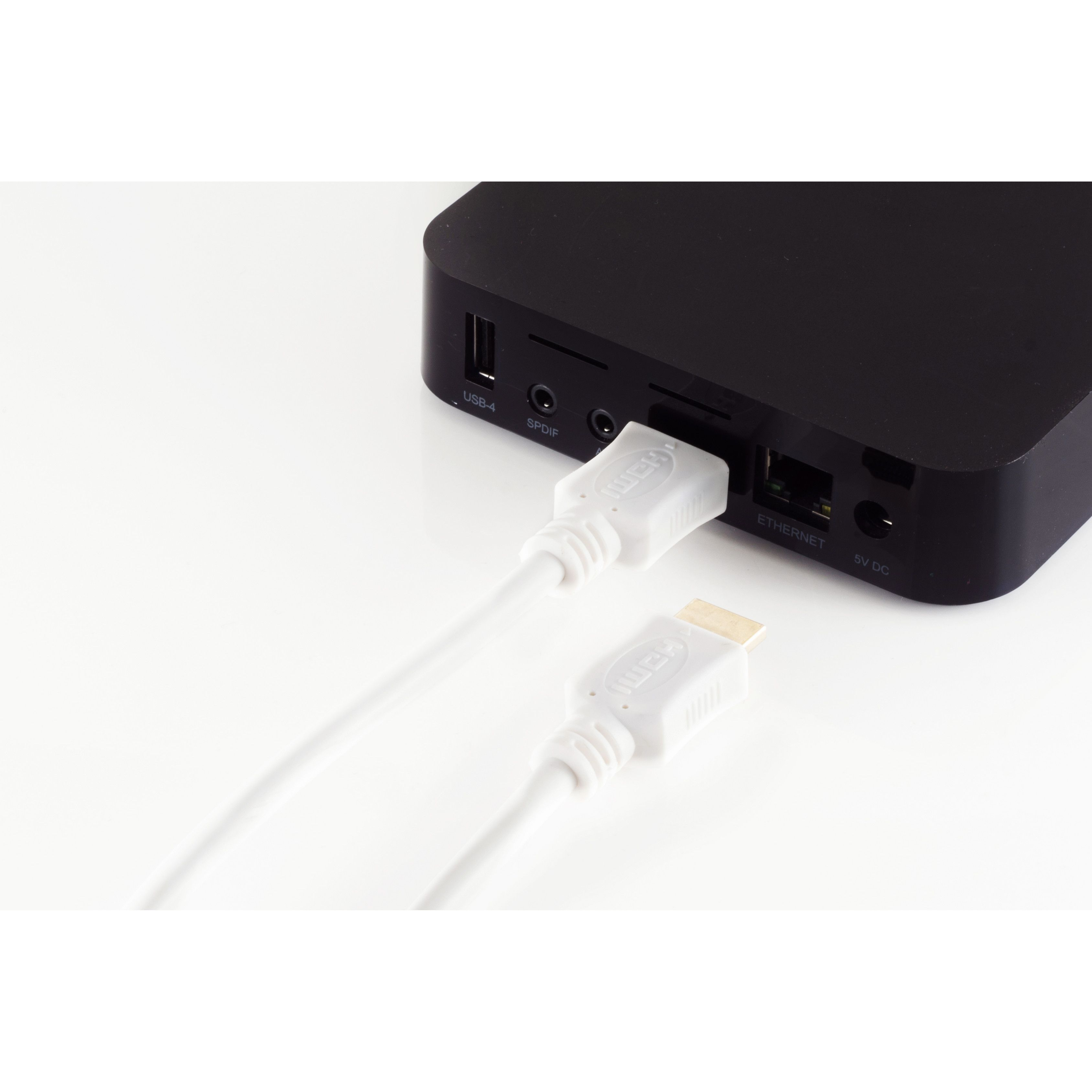 Weißes HDMI-Kabel in ein schwarzes Gerät gesteckt. Ein weiteres weißes Kabel ist in der Nähe.