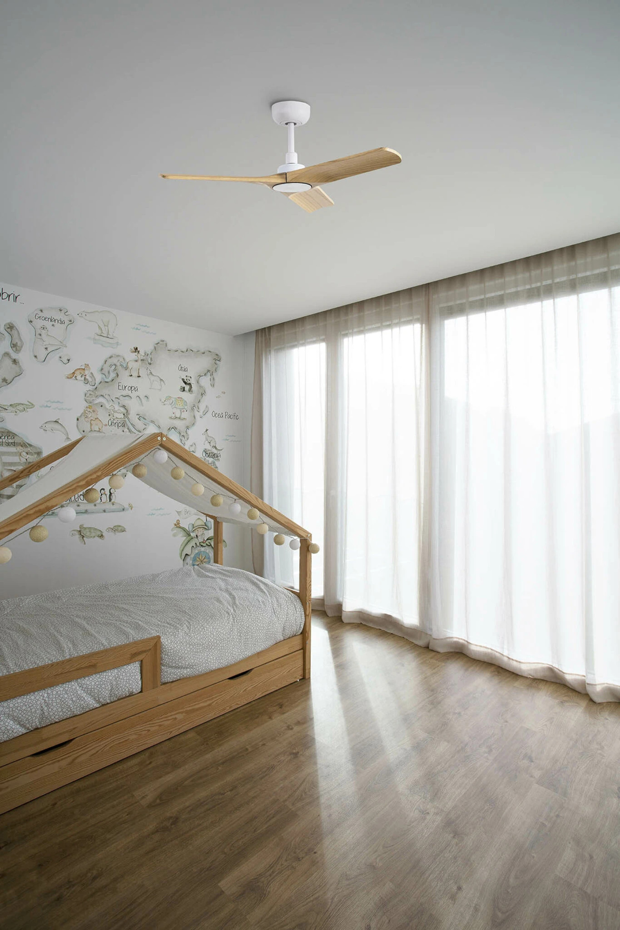Schlafzimmer mit Holzbett, Tapete mit Weltkarte und Deckenventilator.