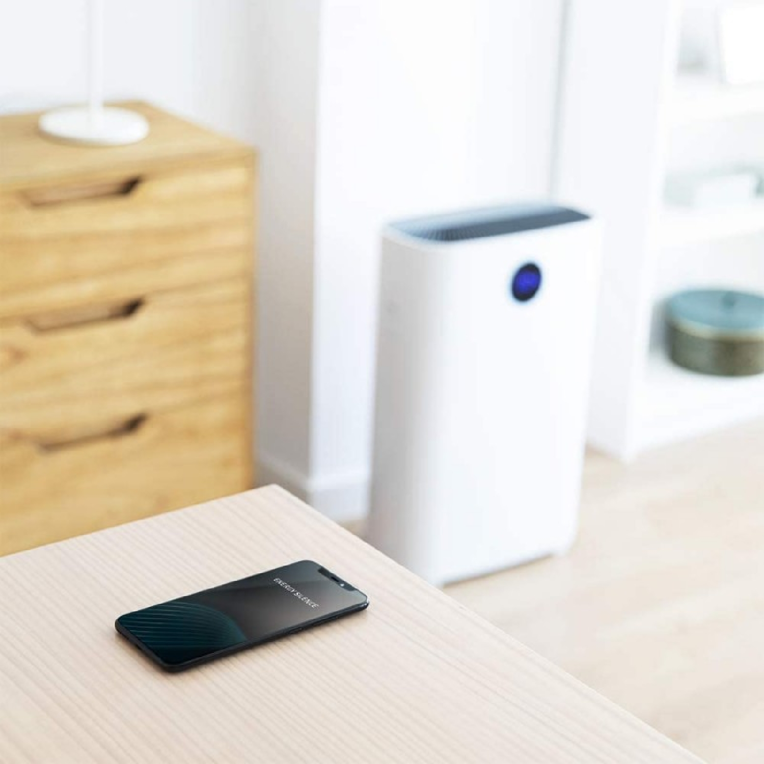 Uno smartphone su un tavolo di legno che mostra un'app di mappe. Un purificatore d'aria è sullo sfondo.