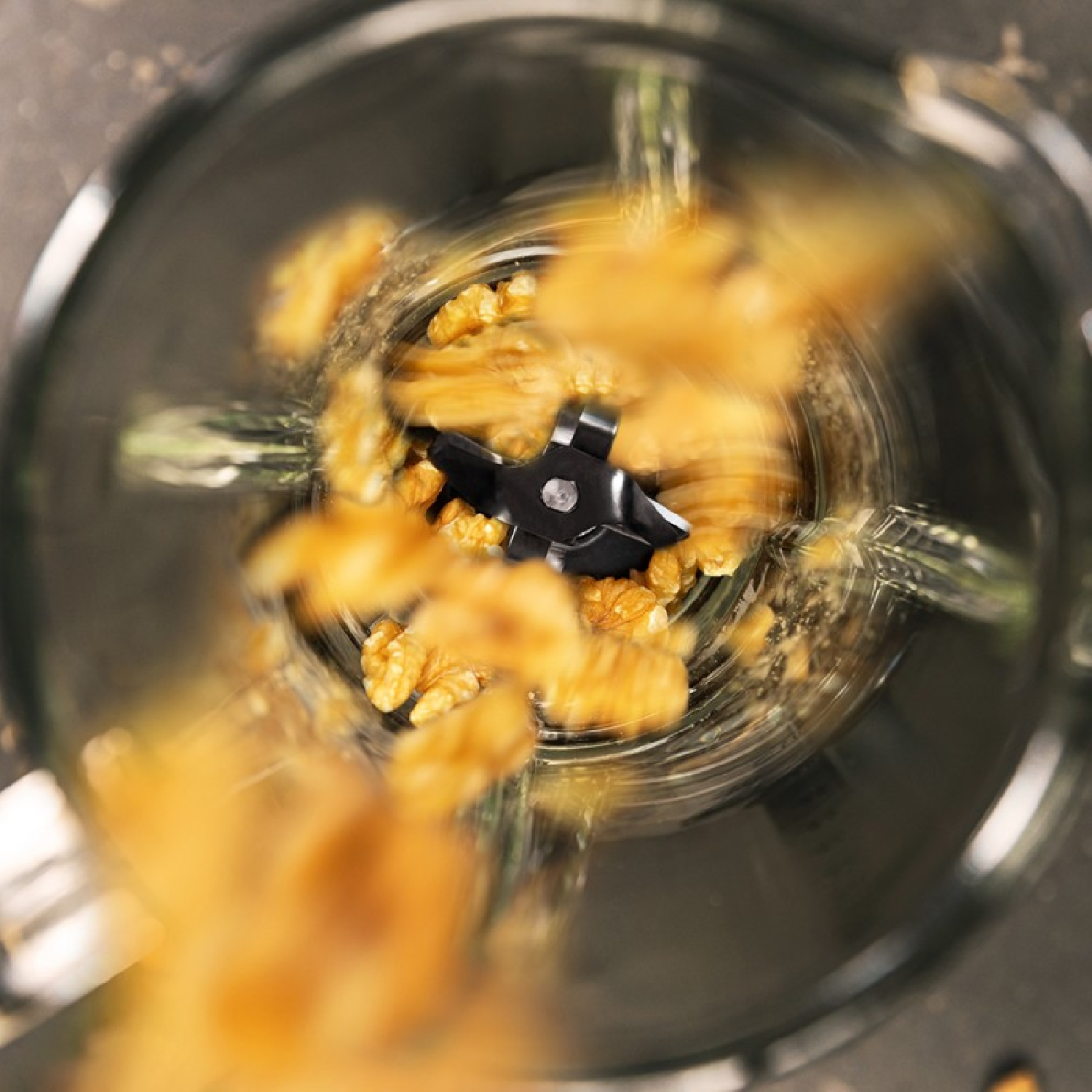 Widok z góry na blender z orzechami włoskimi. Ostrza są widoczne pośrodku.