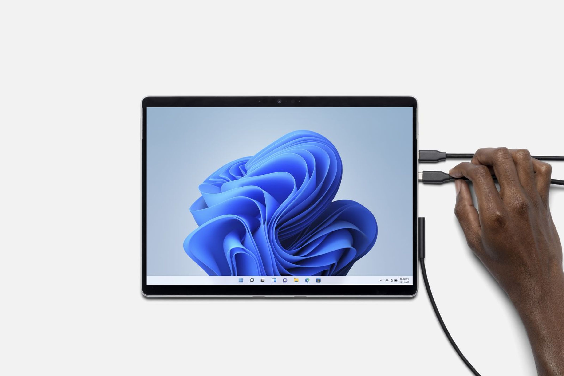 Tablet mit Stromkabel verbunden, blauer Windows-Hintergrund.