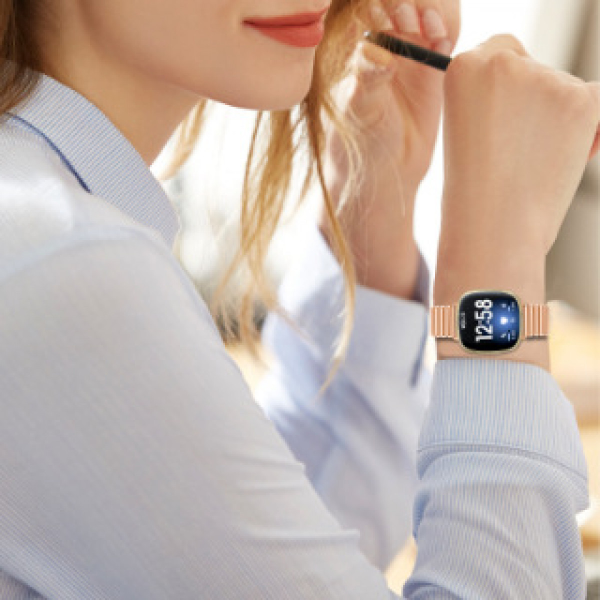 Das Handgelenk einer Frau mit einer roségoldenen Uhr, die die Zeit anzeigt.