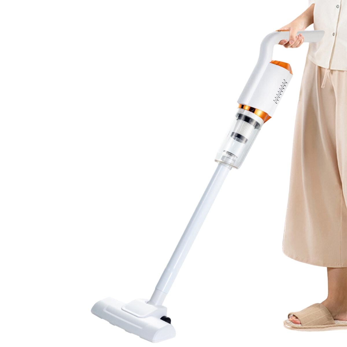 Una mujer sostiene una aspiradora inalámbrica blanca y naranja.