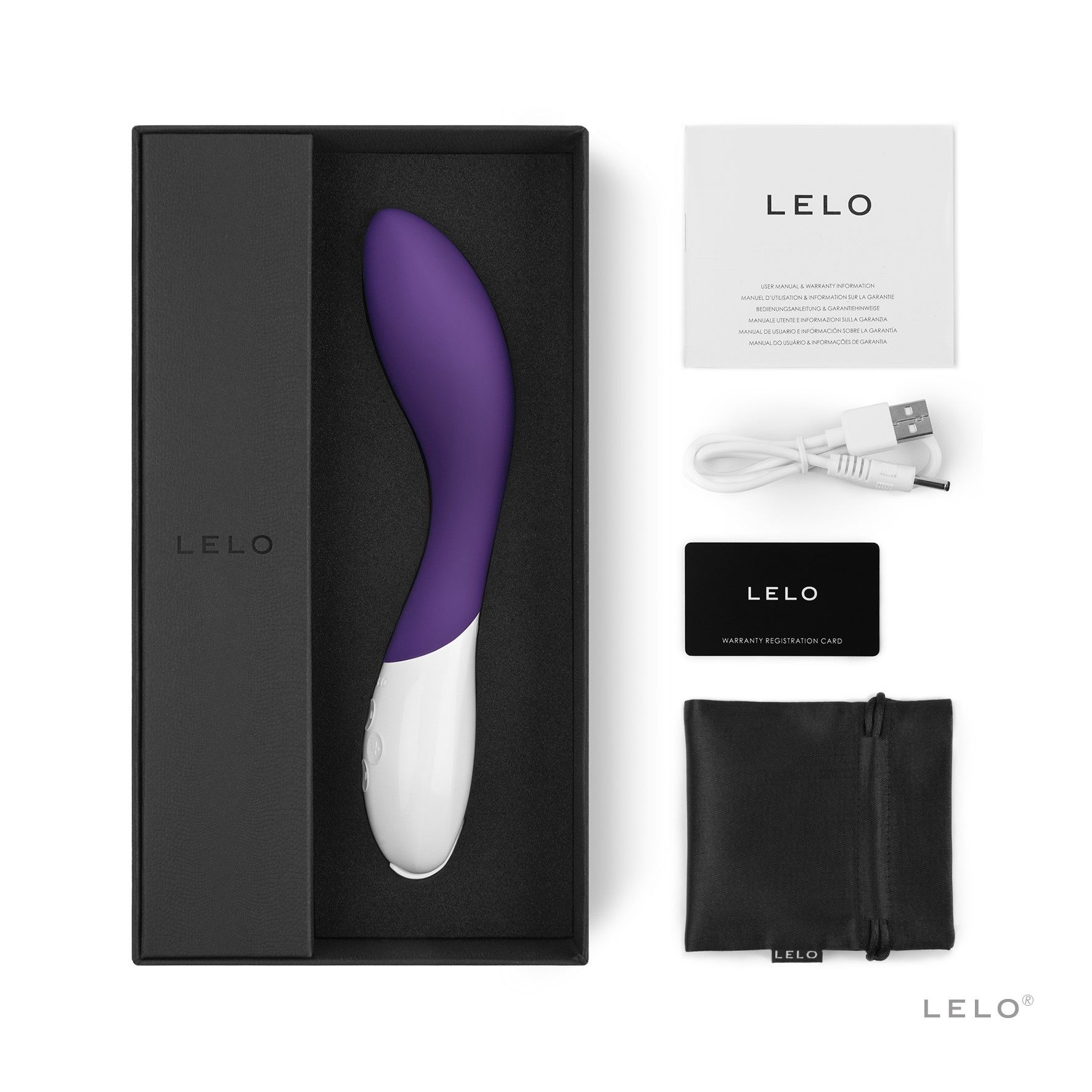 Un juguete sexual morado en su caja con accesorios como un cargador blanco y una bolsa negra, sobre blanco.