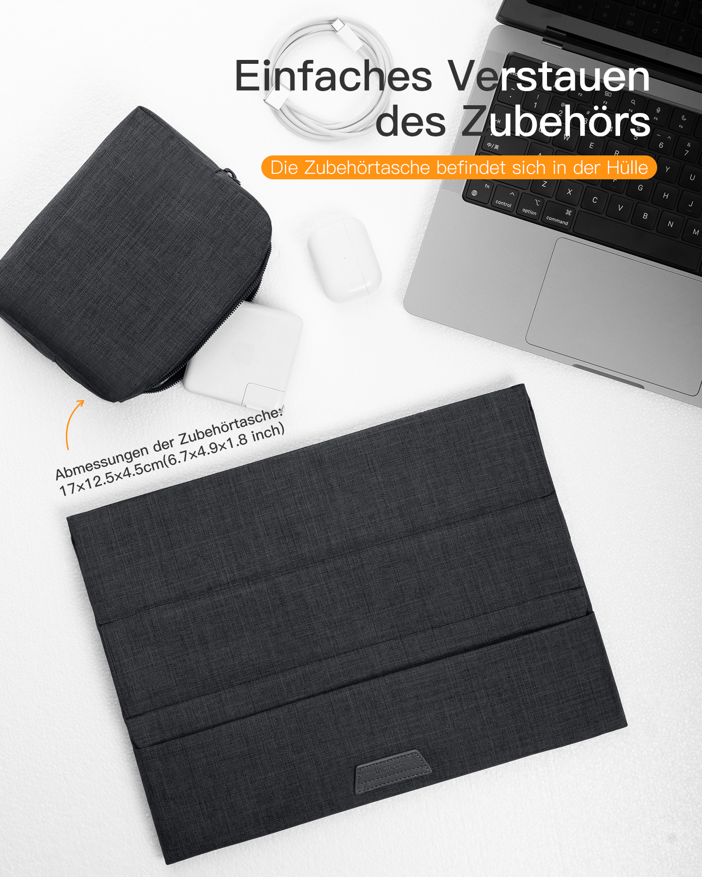 Laptop, dunkelgraues Case, weißes Ladegerät und weiße Maus auf dunkelgrauer Oberfläche.