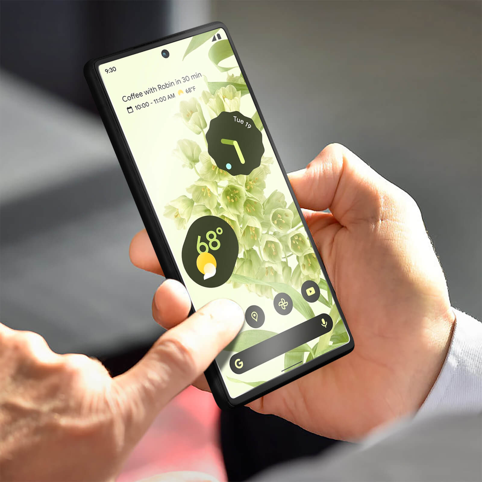 Mano che tiene uno smartphone nero con icone delle app sullo schermo; ora e temperatura visualizzate.