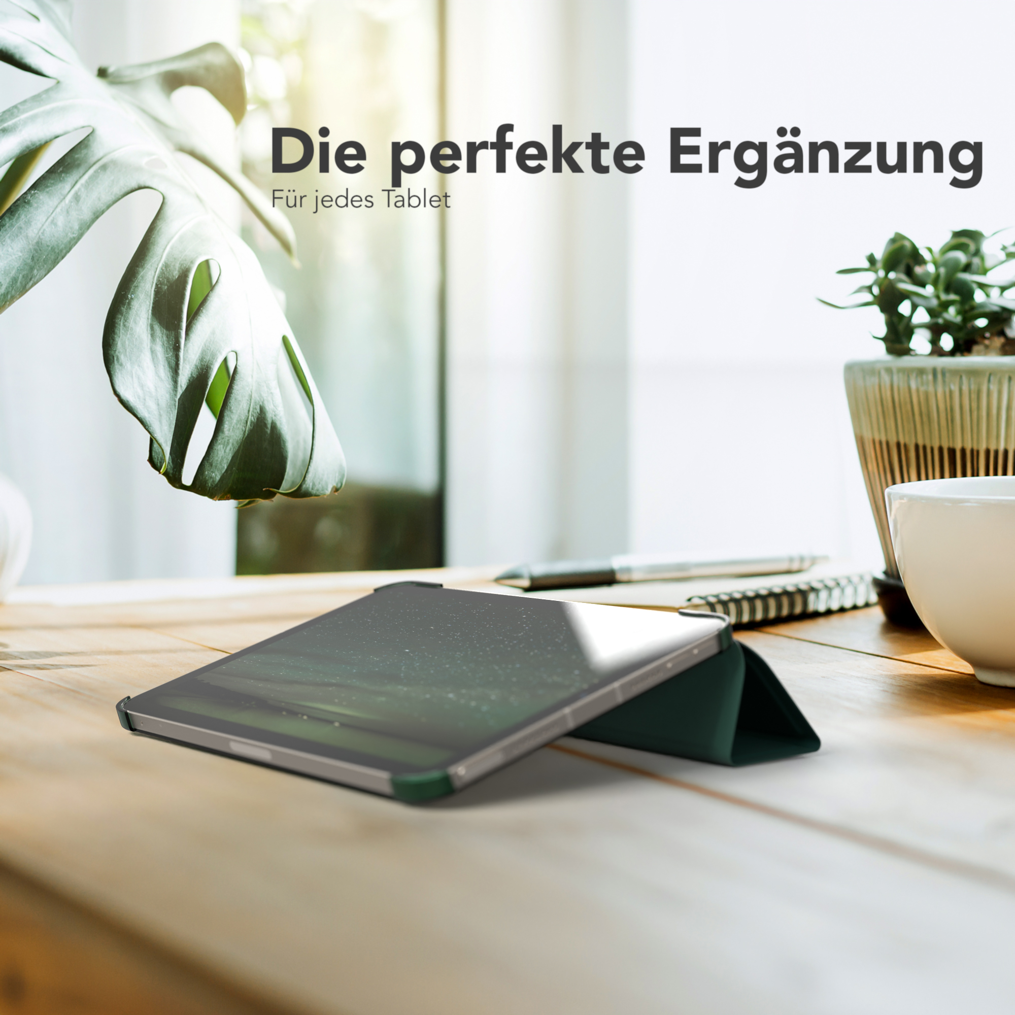 Tablet in grüner Hülle auf Holztisch mit Pflanze und Kaffeetasse. Die perfekte Ergänzung.