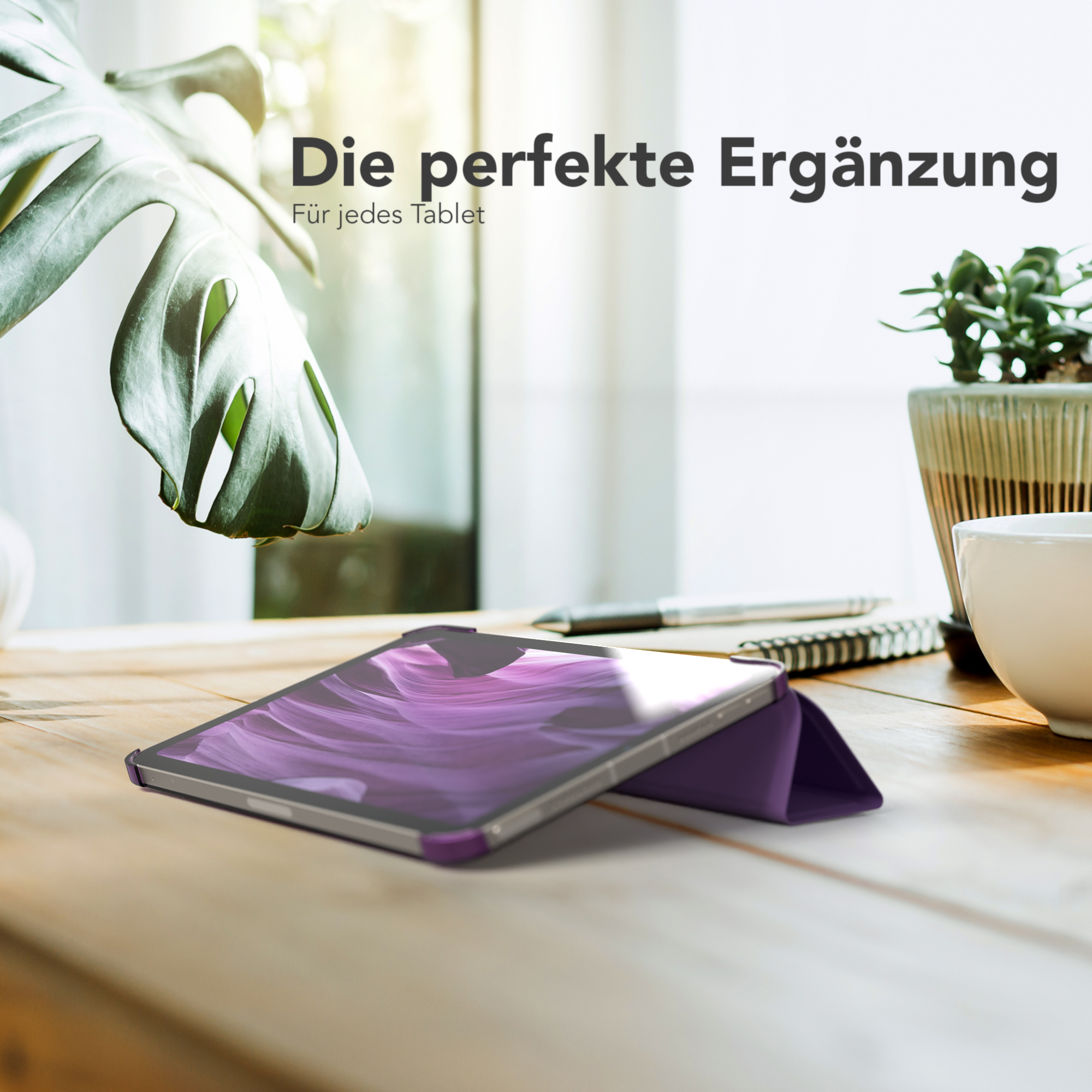 Tablet in einem lila Gehäuse auf einem Holztisch. Grüne Pflanze im Hintergrund. Text: Die perfekte Ergänzung.