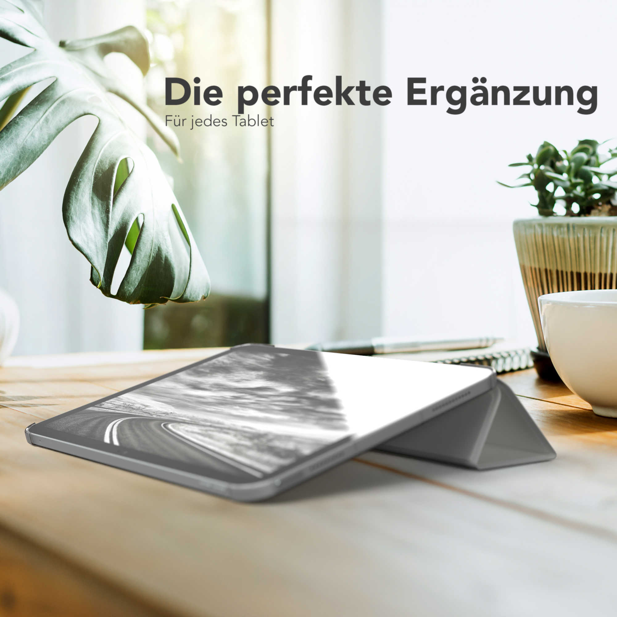 Tablet auf einem Holztisch mit Blättern. Text lautet 'Die perfekte Ergänzung'.