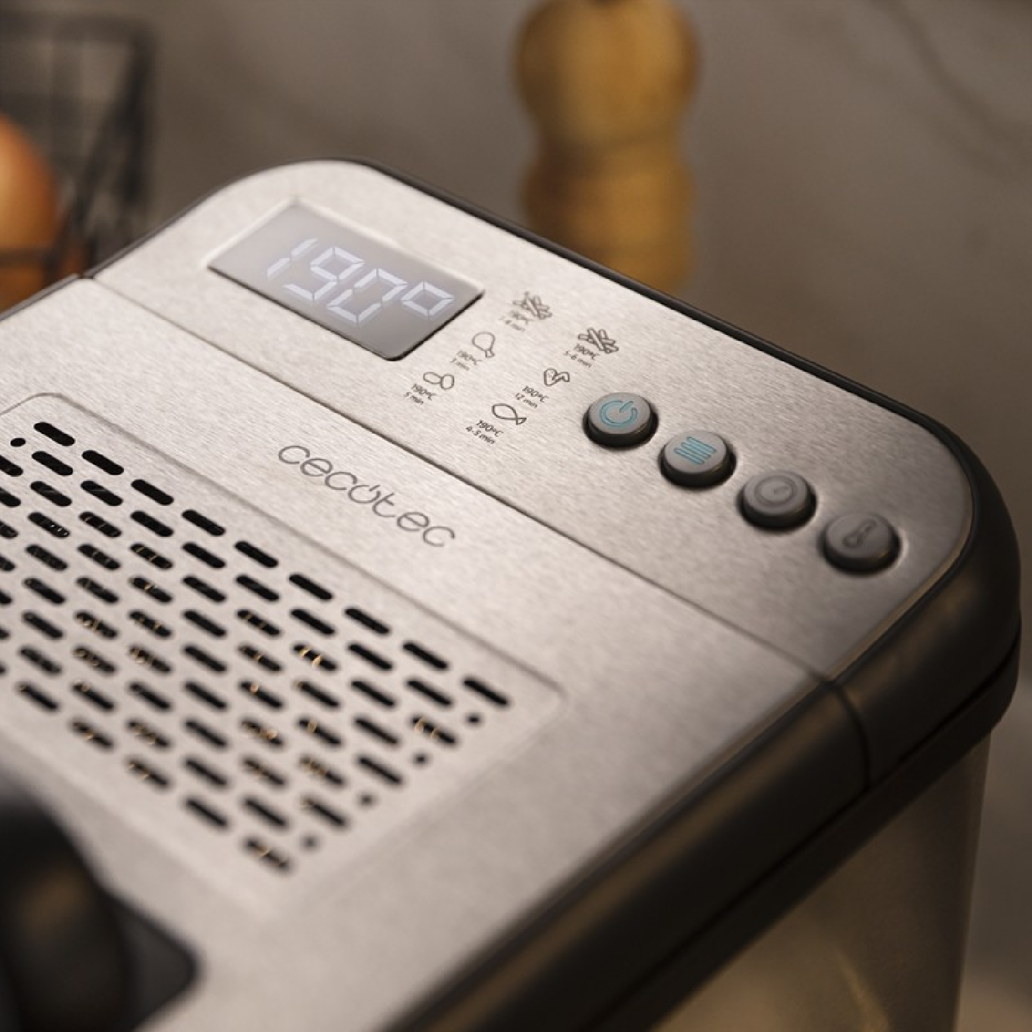 Zbliżenie metalowego panelu sterowania frytkownicy. Wyświetla wyświetlacz cyfrowy i przyciski z symbolami gotowania.