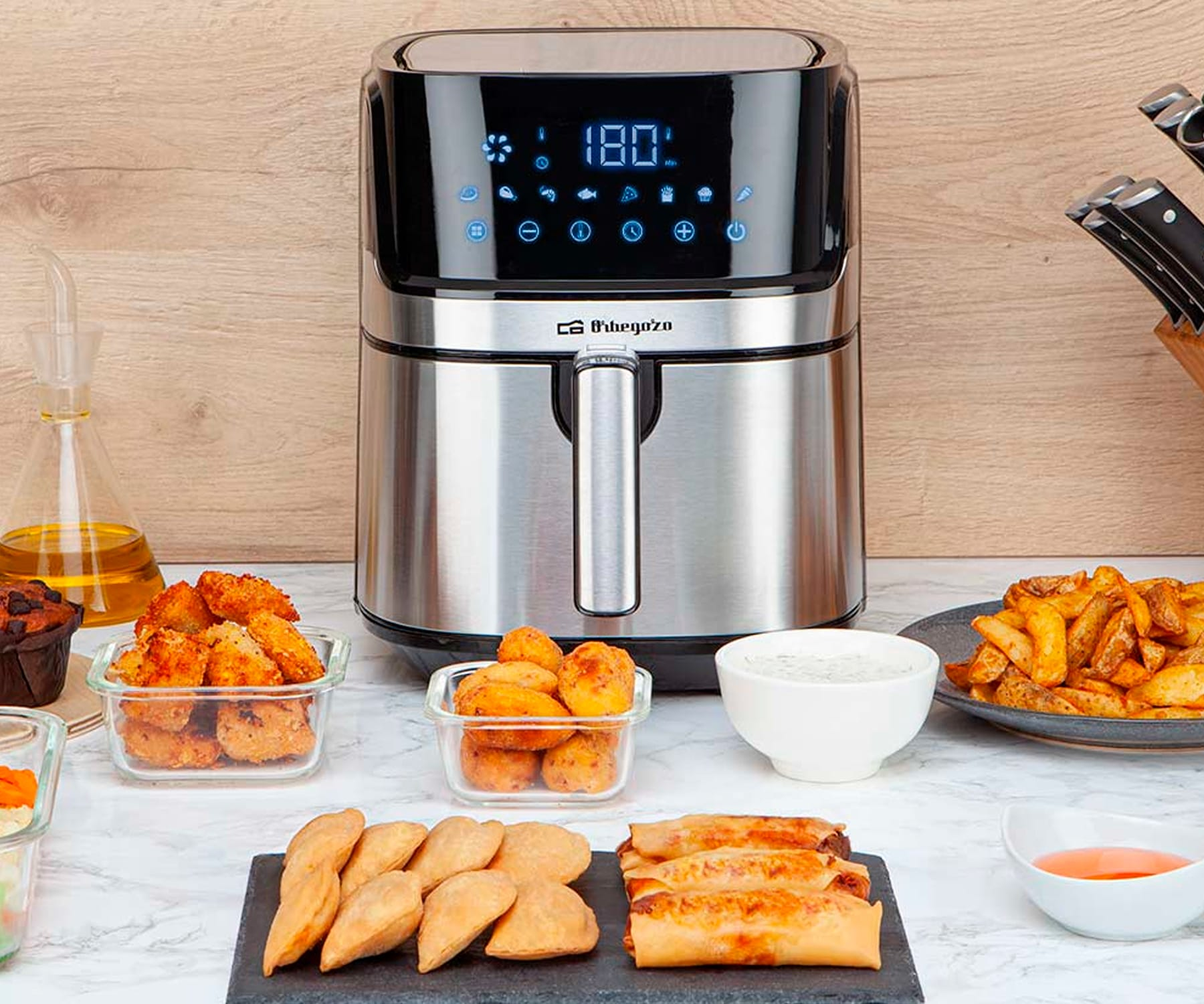 Una friggitrice ad aria con display digitale. Cibo fritto su marmo.
