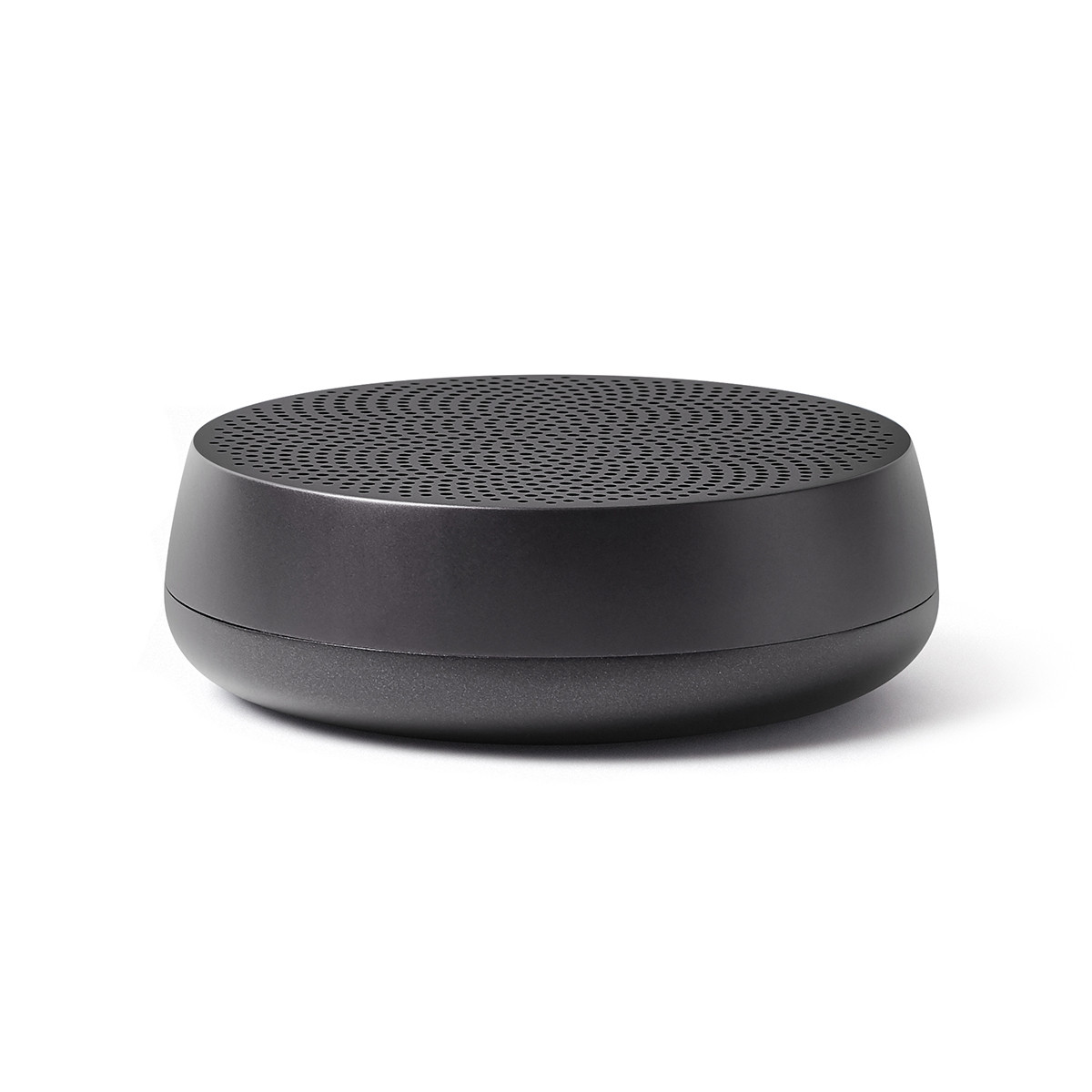 Ciemnoszary głośnik na białym tle. Perforowana górna powierzchnia.