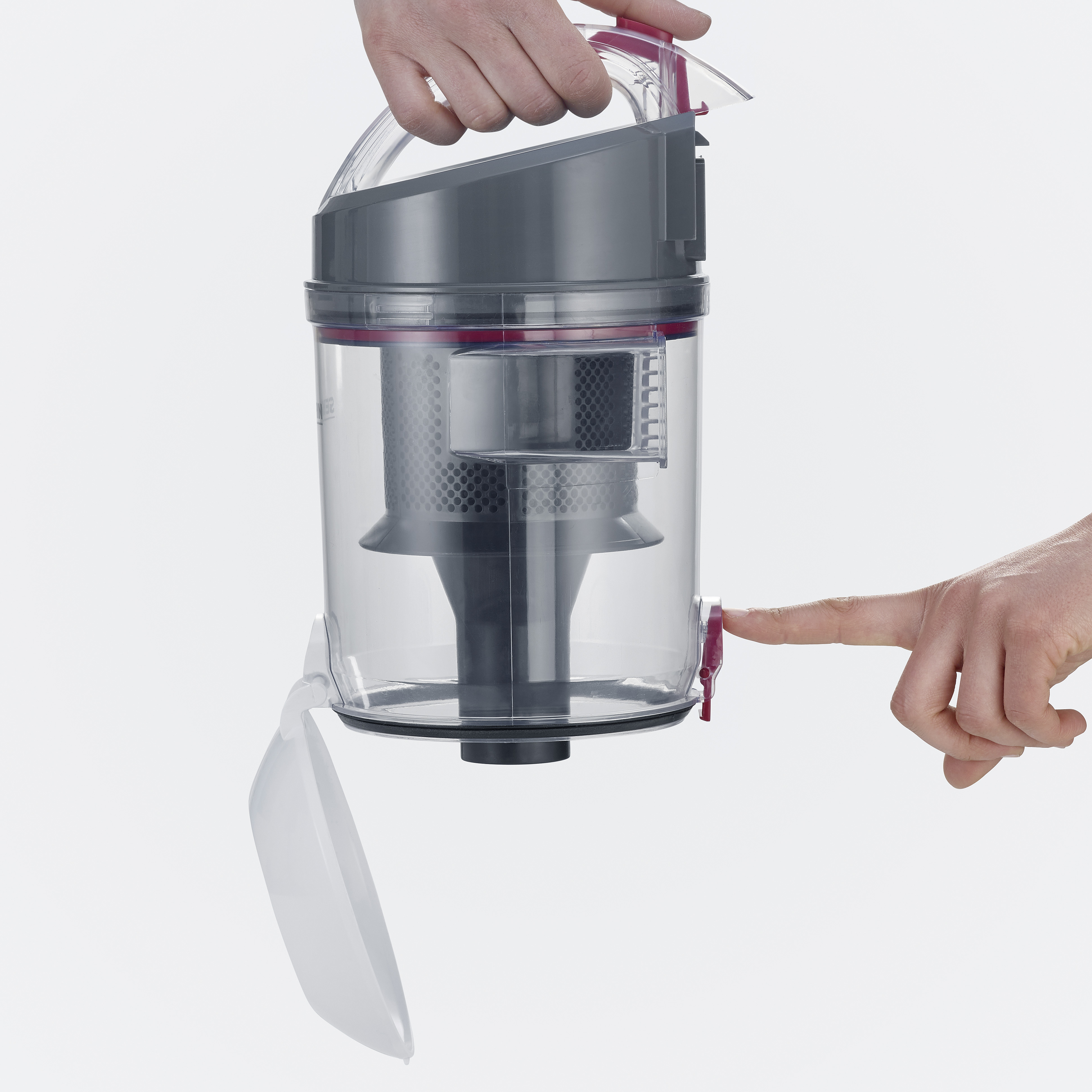 Przezroczysty pojemnik odkurzacza otwierany przez osobę. Czerwone akcenty. Białe tło.