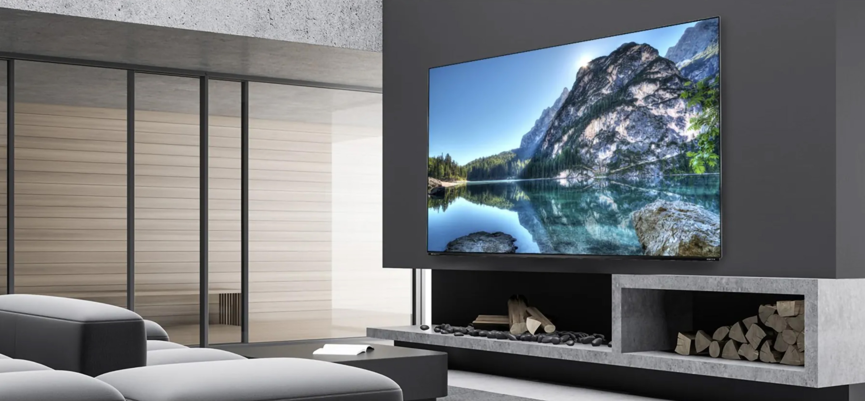 Duży telewizor zamontowany na szarej ścianie nad kominkiem z krajobrazem na ekranie.