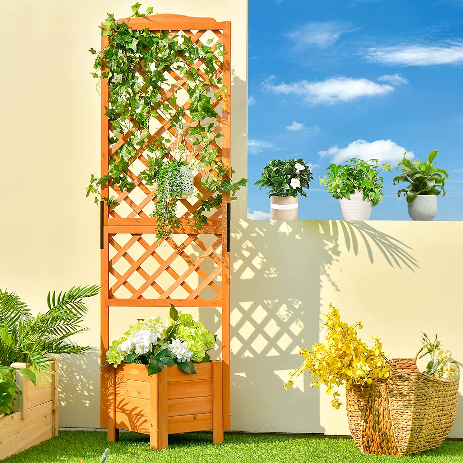 Holzspalier mit Pflanzen, Pflanzkasten, Korb mit Blumen und kleine Topfpflanzen.
