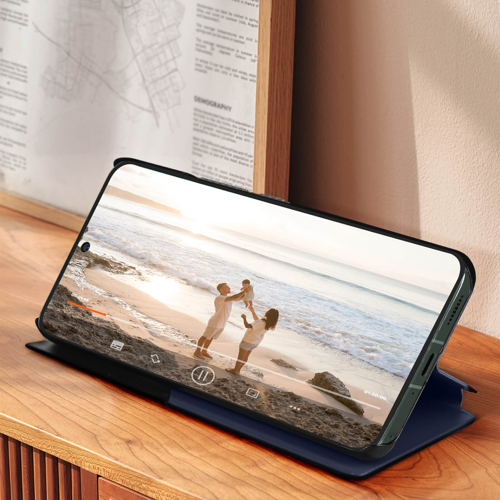 Tablet mit Hülle, die ein Video einer Familie am Strand zeigt, auf einem Tisch.