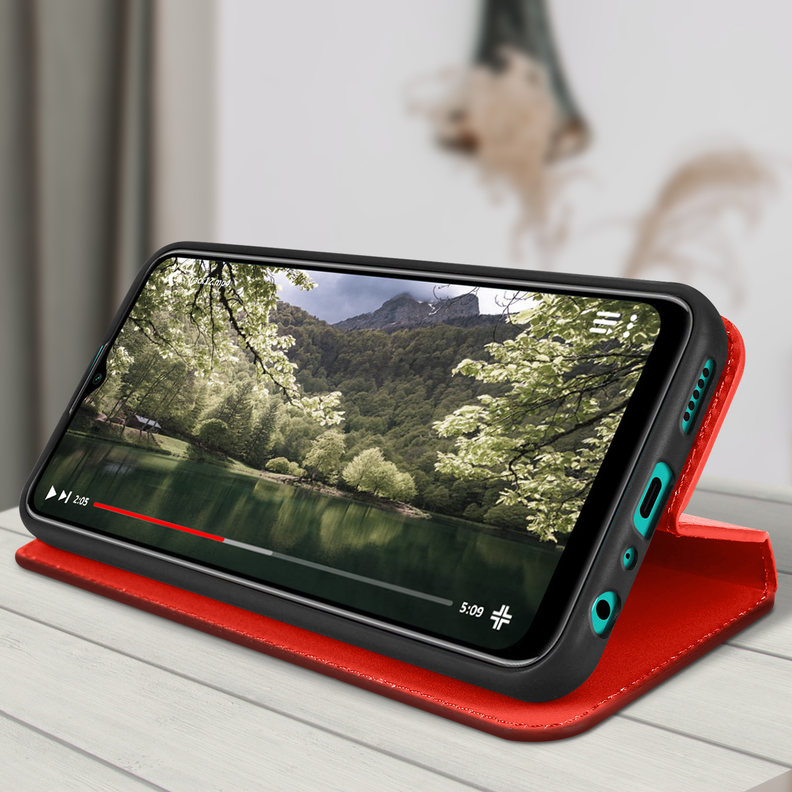 Telefono in custodia rossa che riproduce un video. La custodia è aperta, e sullo sfondo un ufficio sfocato.