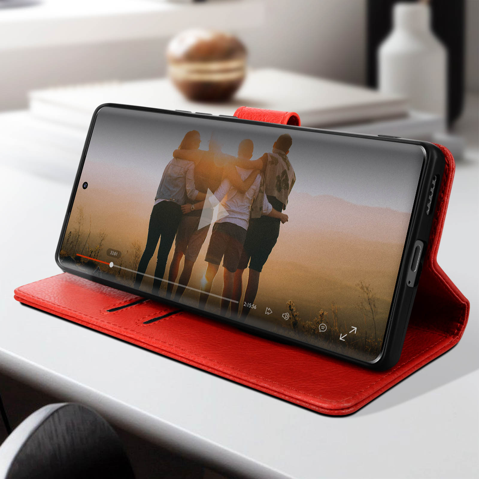 Custodia per telefono rossa aperta, con un telefono che mostra un video, con la parte inferiore visibile.