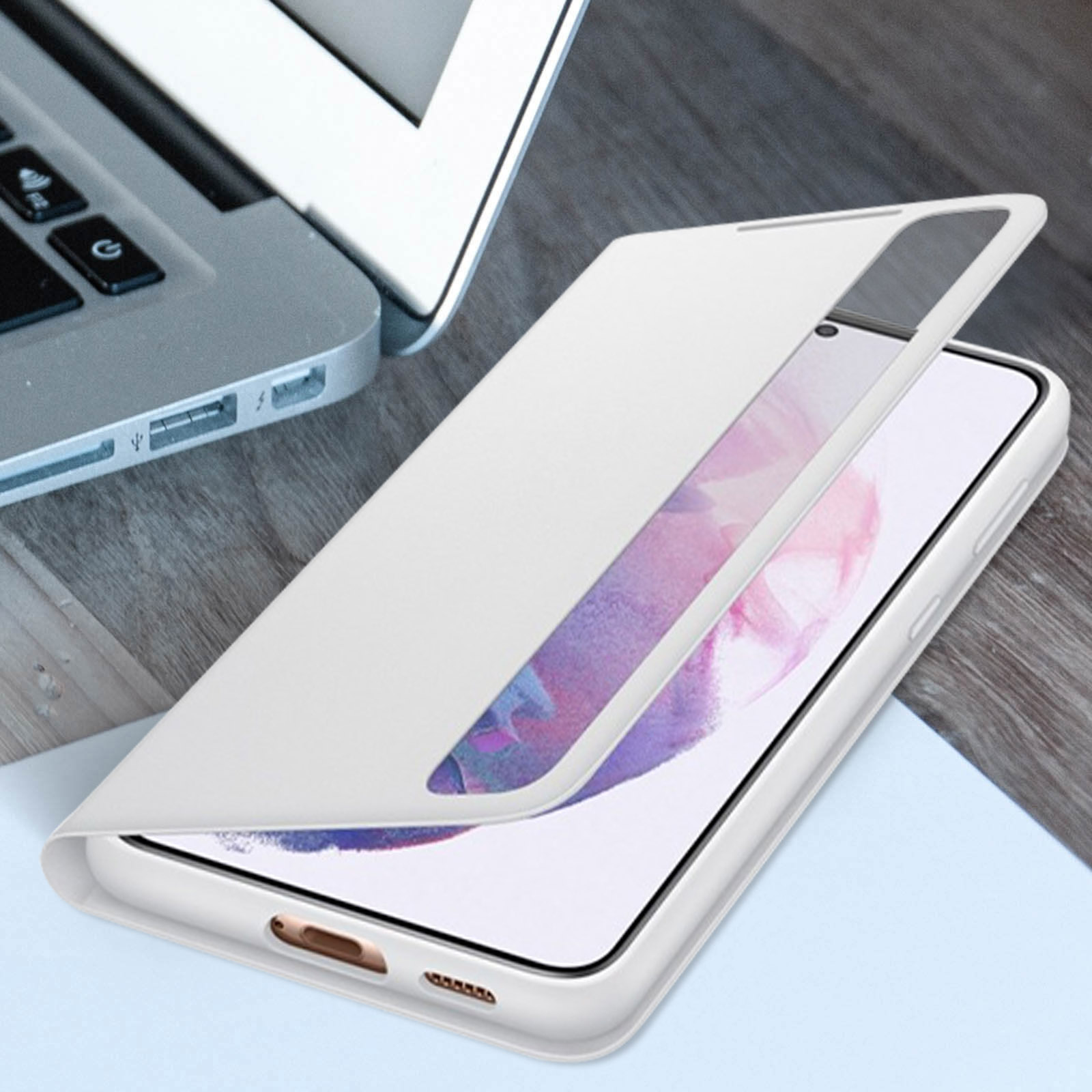 Weiße Handyhülle mit einem Telefon darin, geöffnet. Das Telefon ist weiß, auf einem Holzschreibtisch in der Nähe eines Laptops.