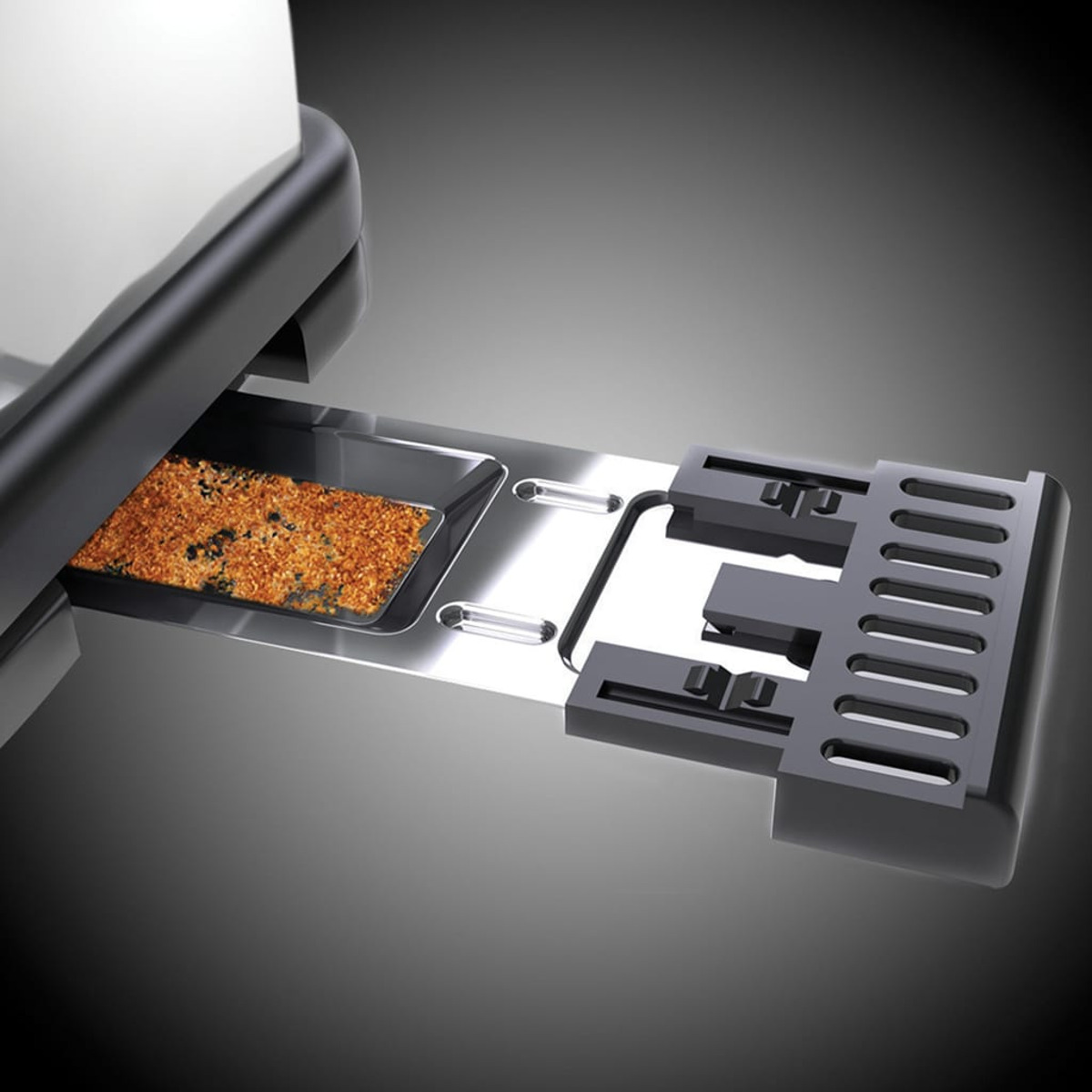 Die Krümelschublade eines Toasters mit Krümeln wird gezeigt. Die Schublade ist herausgezogen.